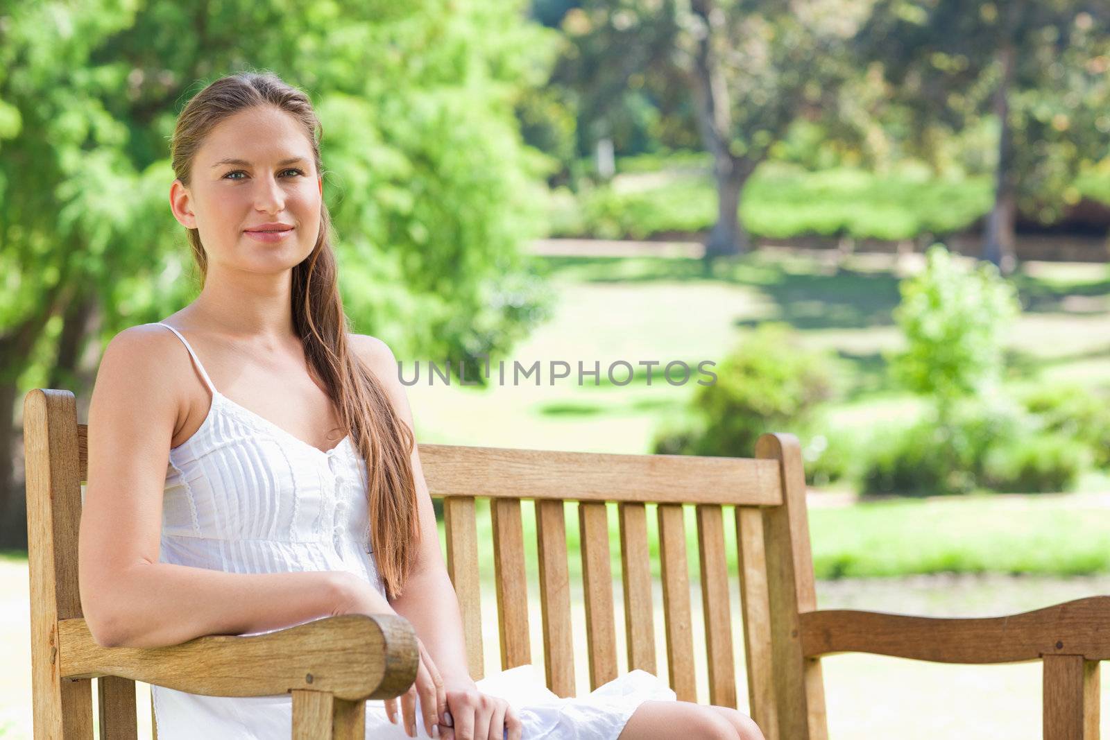 Woman sitting on a bench in the park by Wavebreakmedia
