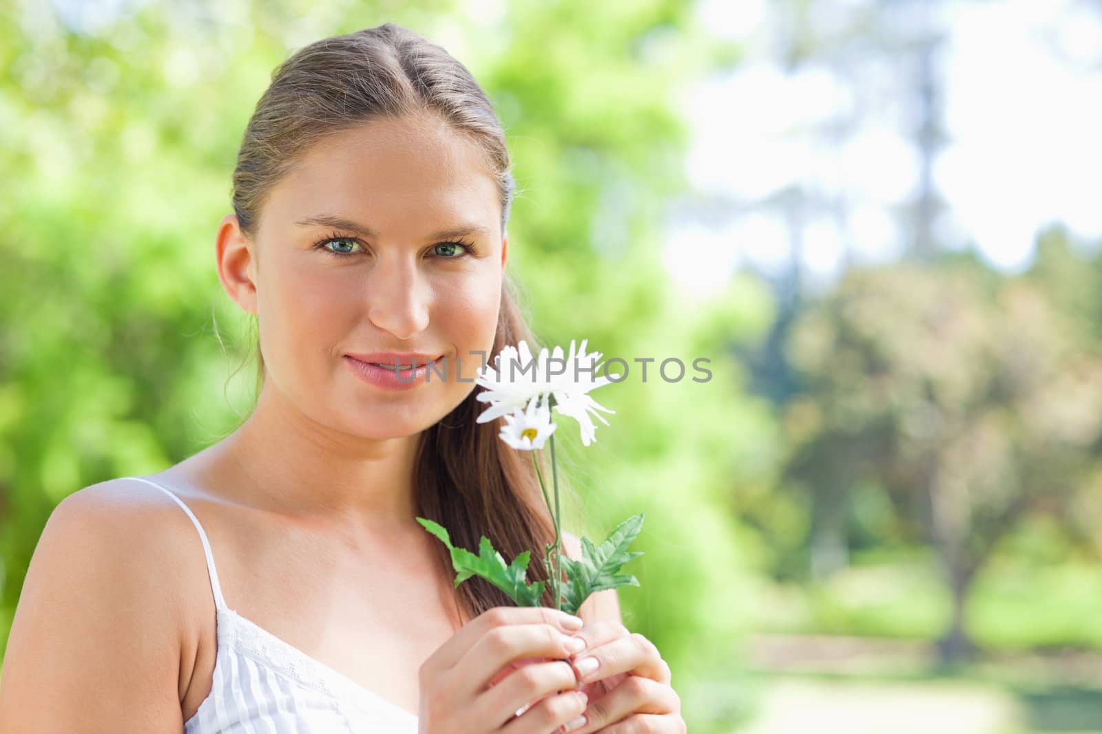 Woman holding a flower in the park by Wavebreakmedia