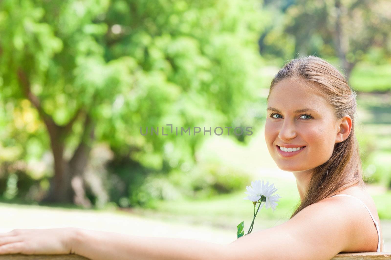 Side view of a smiling woman with a flower by Wavebreakmedia