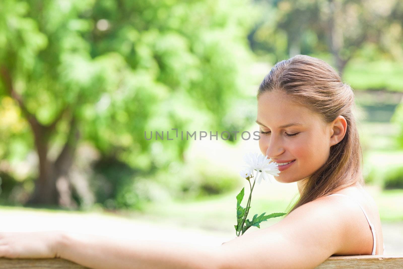 Side view of a woman smelling a flower by Wavebreakmedia