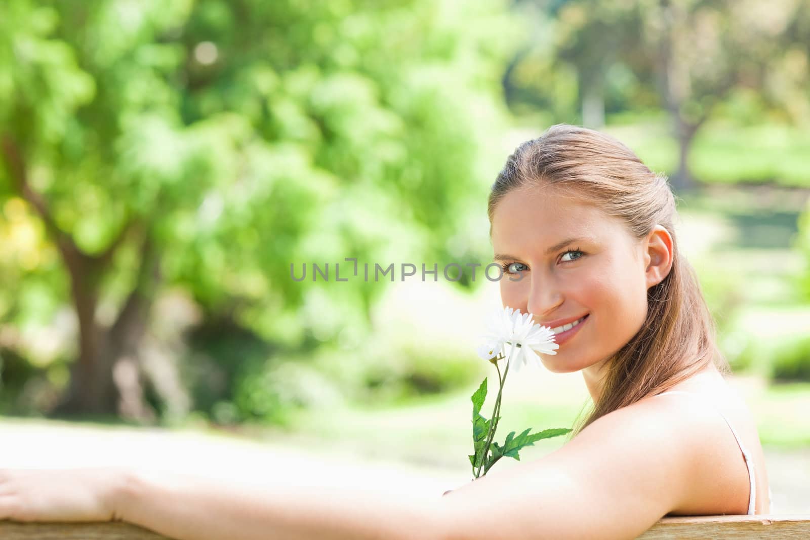 Side view of a smiling woman smelling a flower by Wavebreakmedia