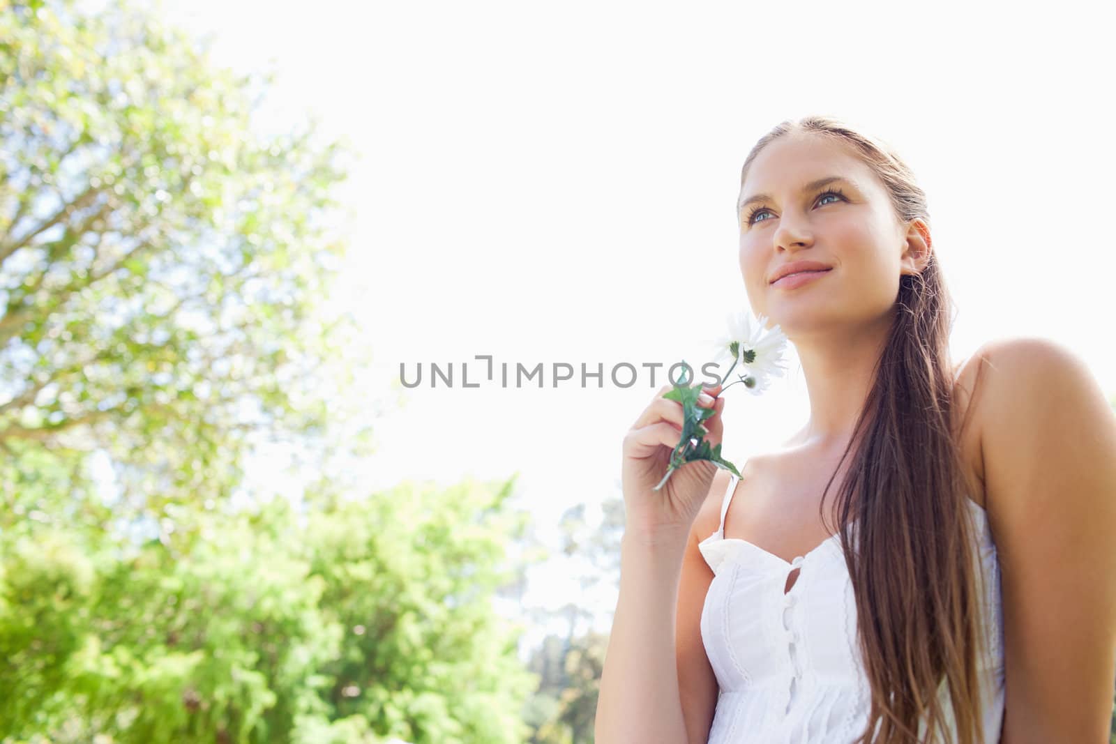 Young woman with flower enjoying the day in the park