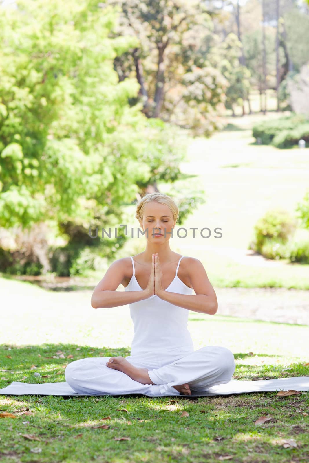 Woman in a yoga position sitting on the lawn by Wavebreakmedia