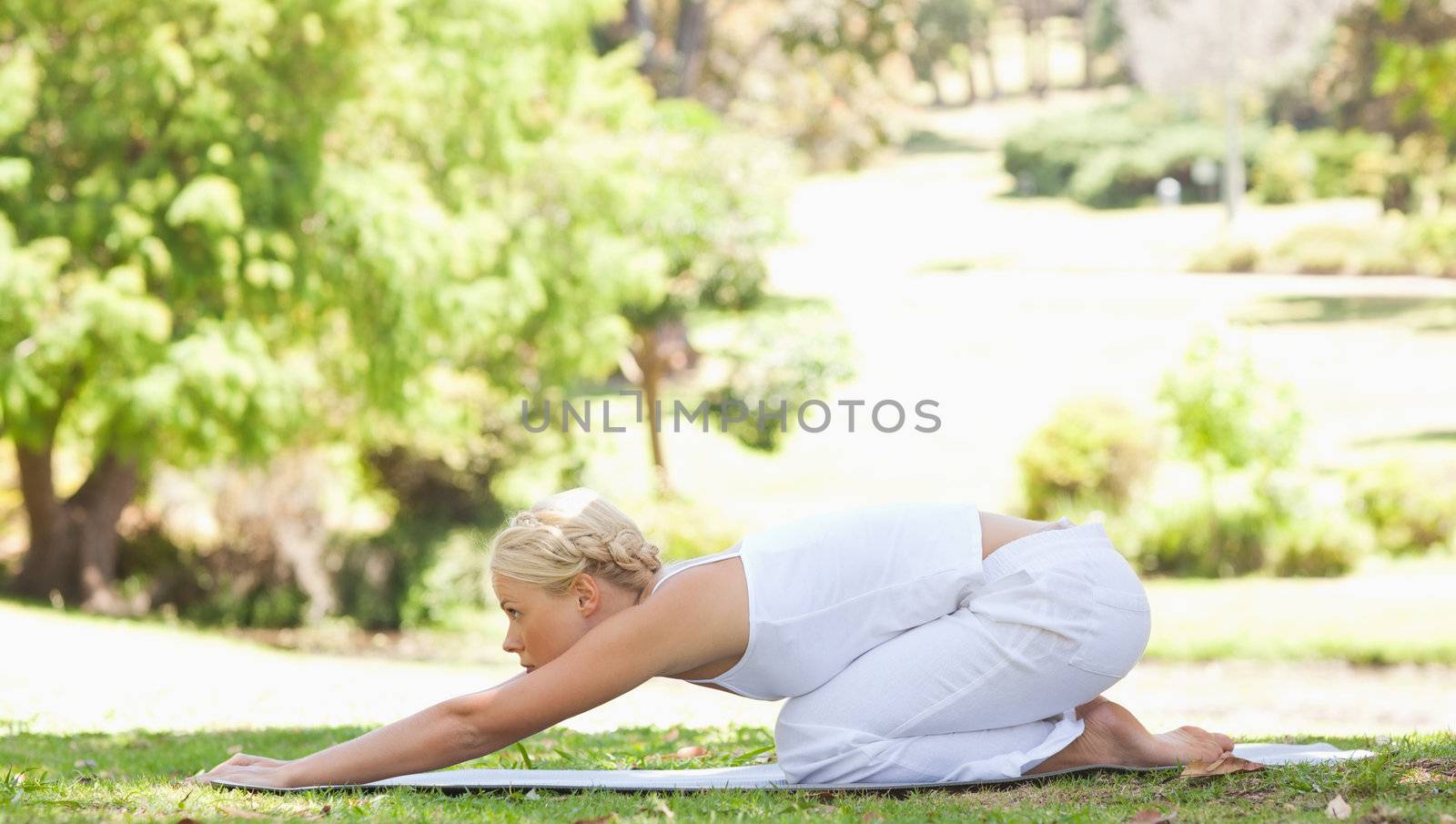 Side view of a young woman doing stretches in the park