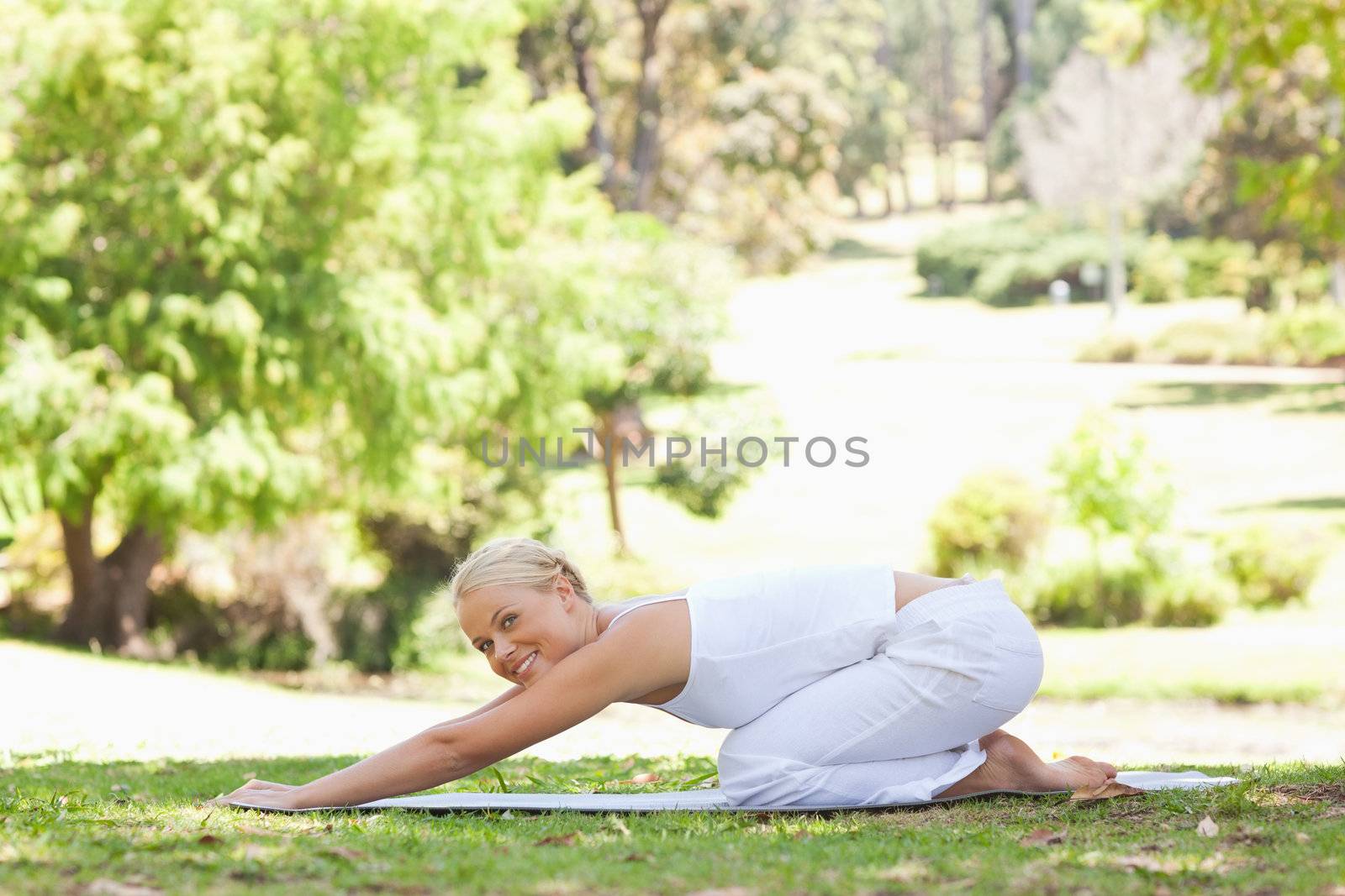 Side view of a woman doing stretches on the lawn by Wavebreakmedia