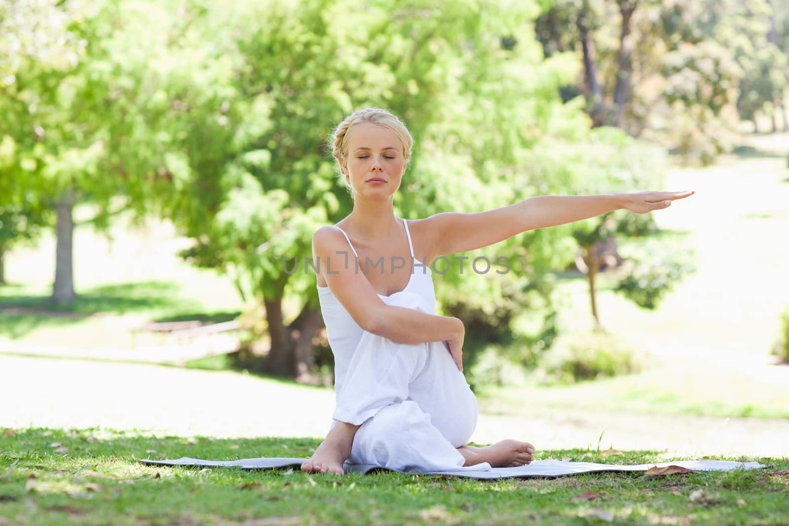 Young woman in the park doing yoga exercises