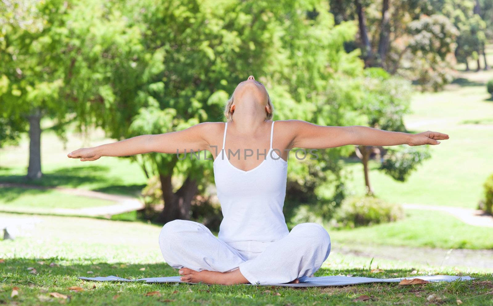 Woman on the lawn doing yoga exercises by Wavebreakmedia