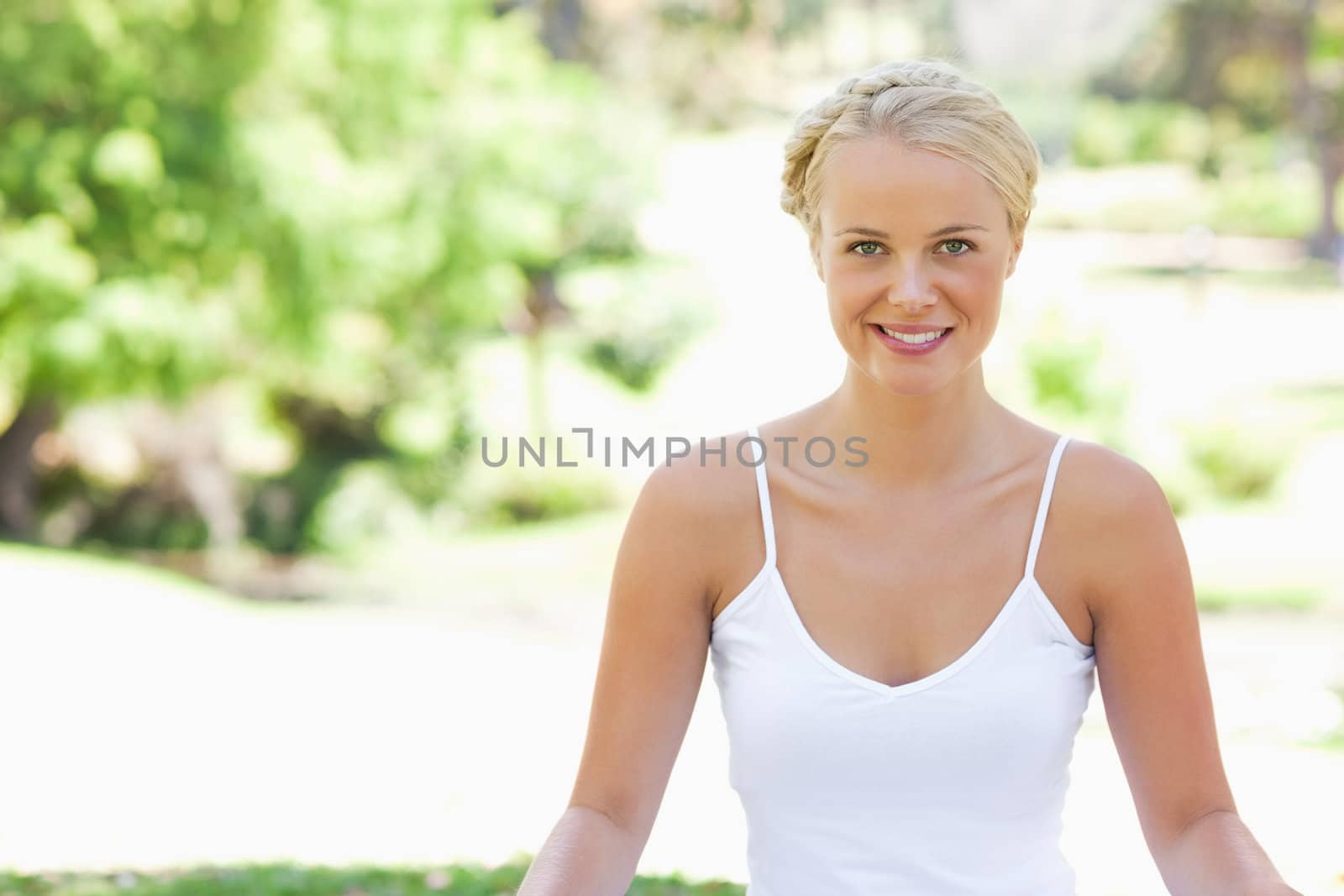Relaxed smiling woman sitting on the lawn by Wavebreakmedia