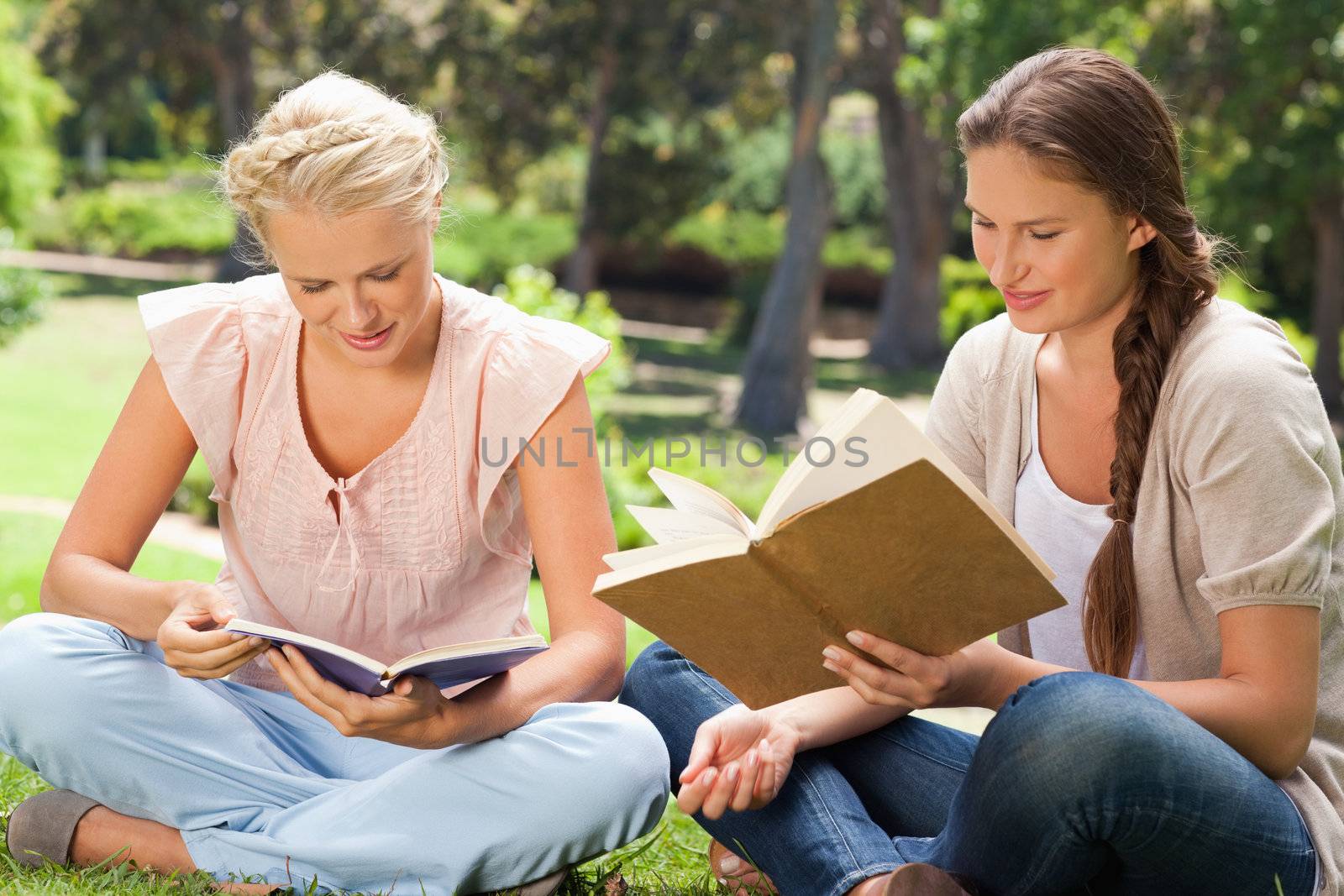 Female friends reading books in the park