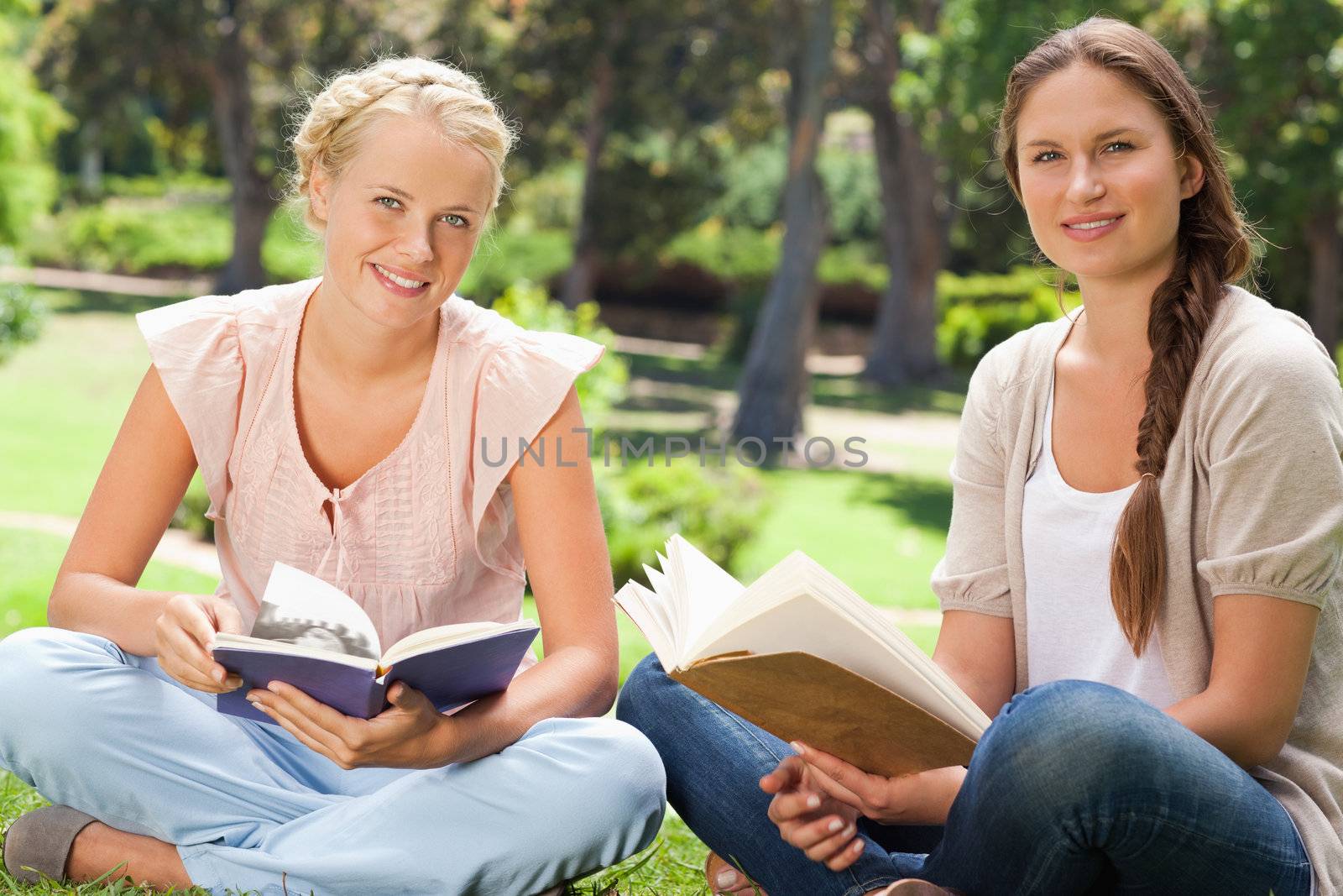 Female students sitting in the park with their books