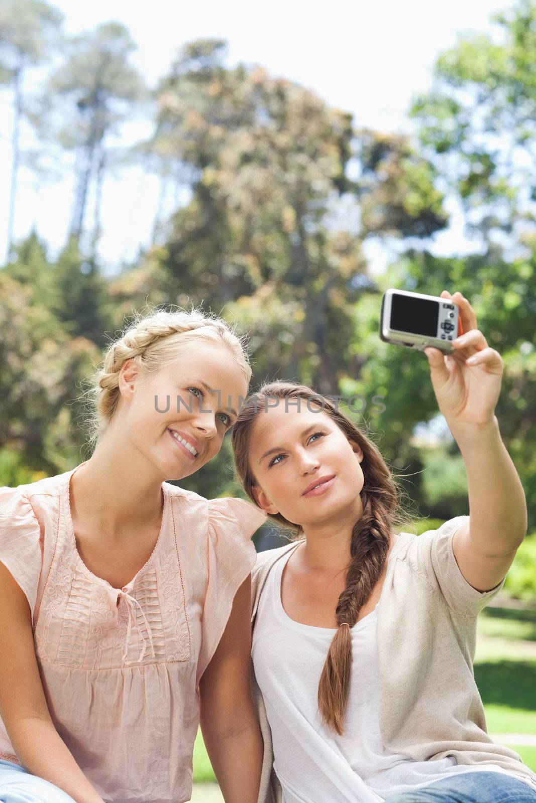 Young woman taking a picture of herself and a friend