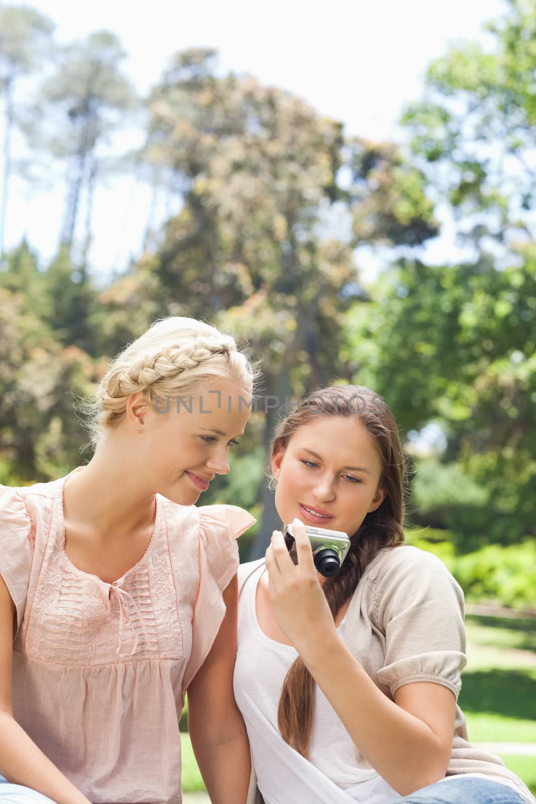 Friends looking at recent photos on their camera by Wavebreakmedia