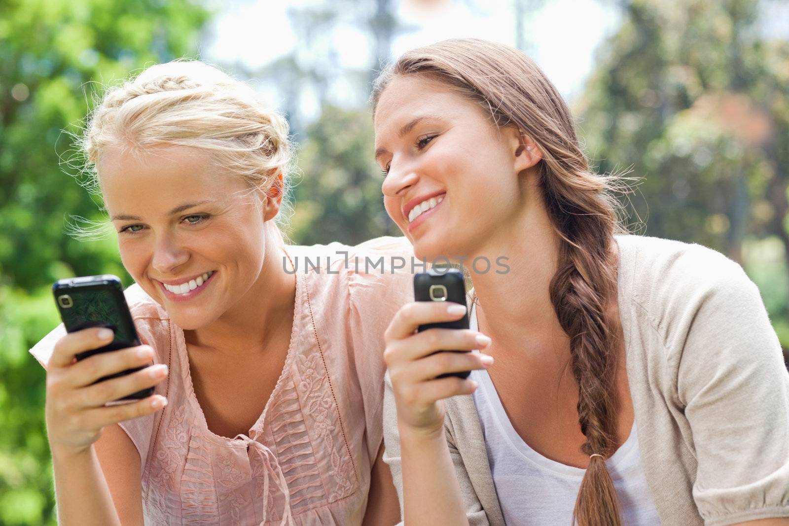 Smiling friend with cellphones by Wavebreakmedia