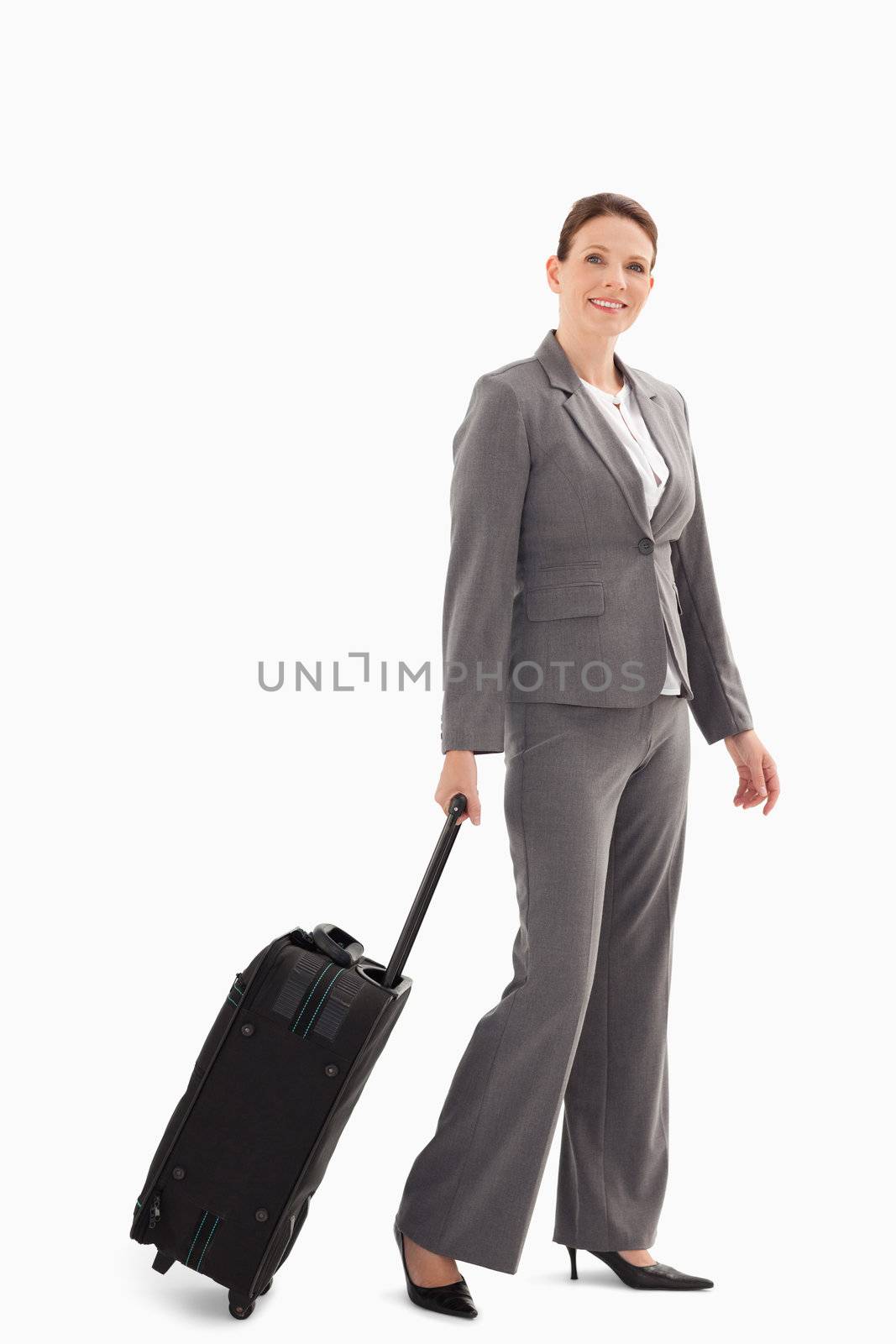 A businesswoman is walking with a suitcase