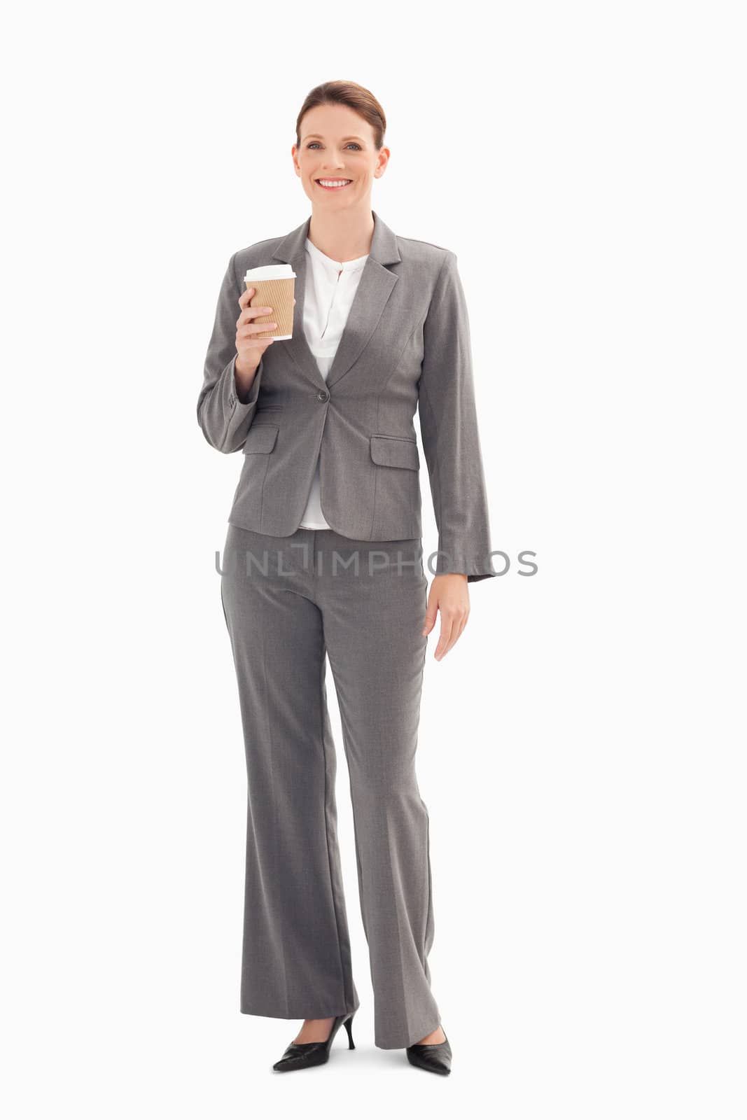 Smiling businesswoman holding cup of coffee  by Wavebreakmedia