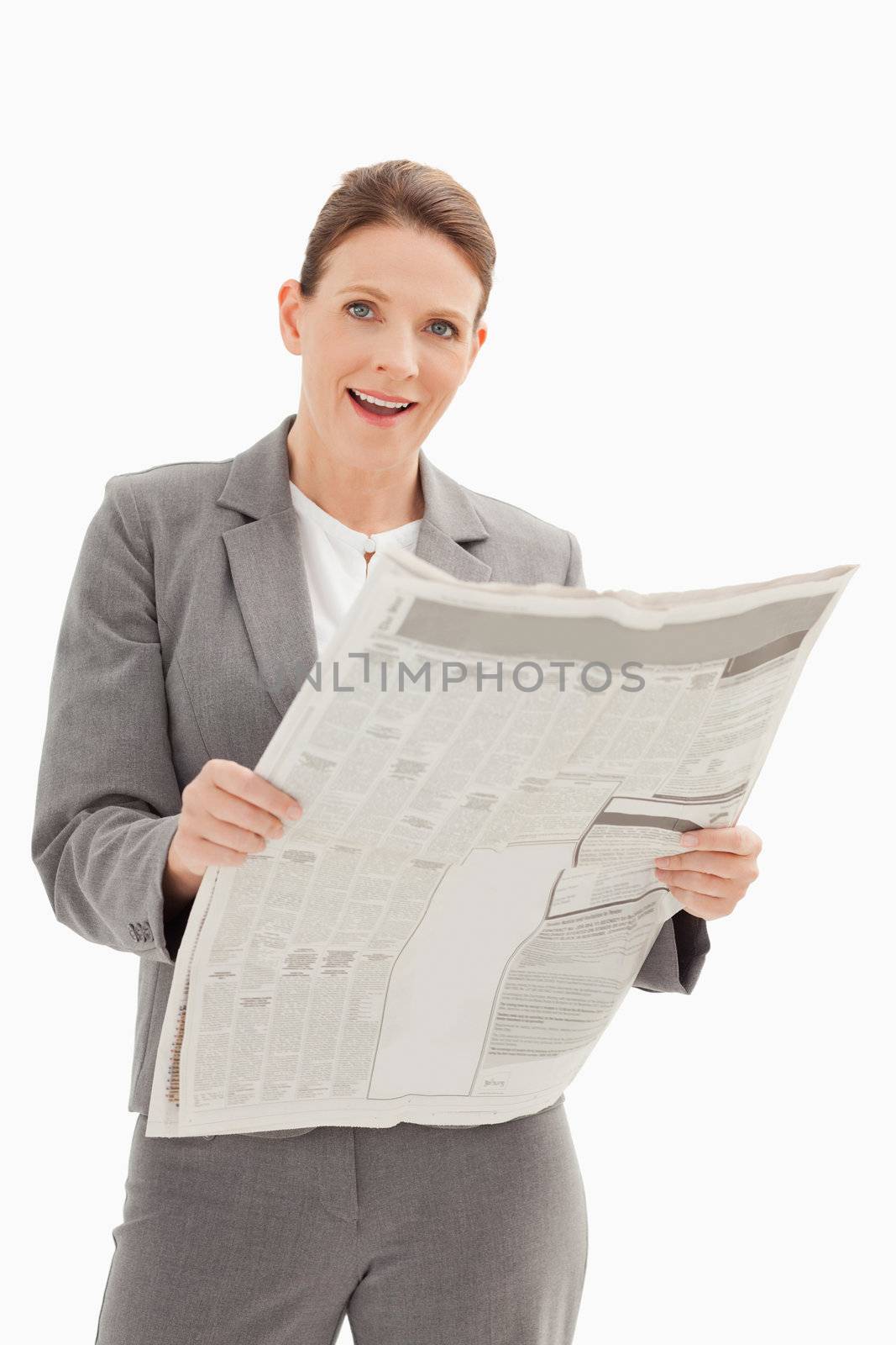 A surprised businesswoman is holding a newspaper