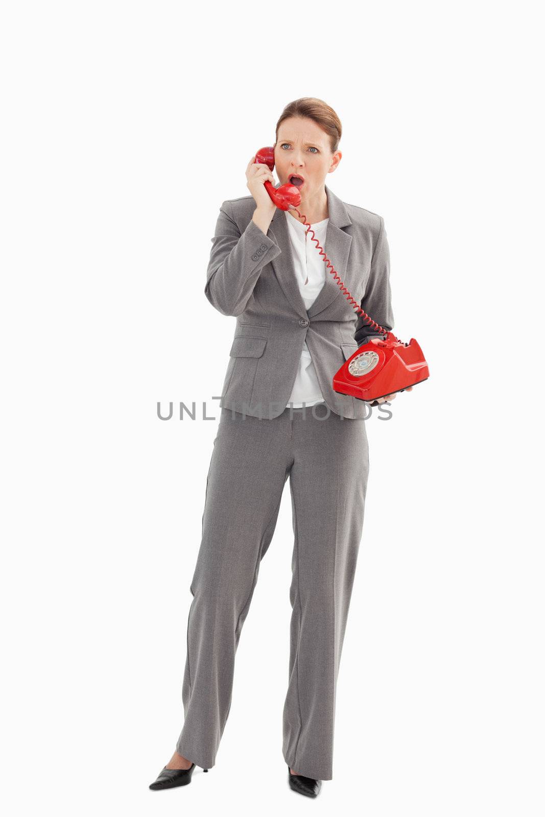 An angry businesswoman is talking on the phone