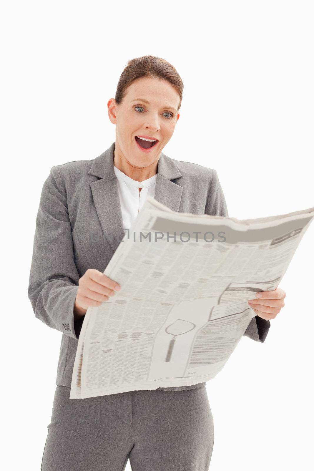 Surprised businesswoman standing reading the newspaper by Wavebreakmedia