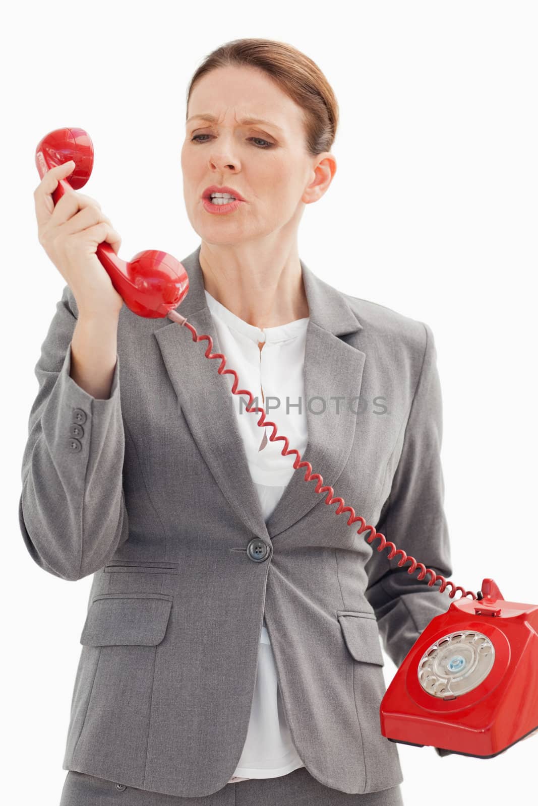 An angry businesswoman is shouting at the phone