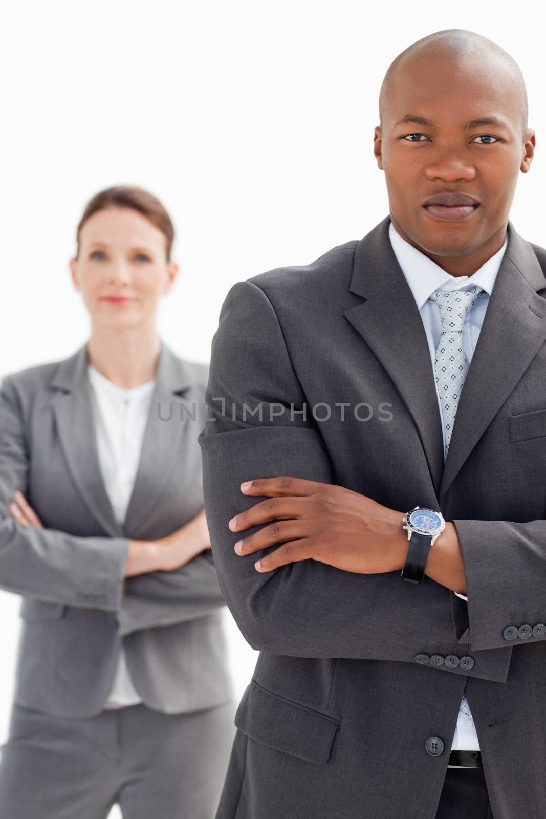 Businesswoman stands behind businessman by Wavebreakmedia