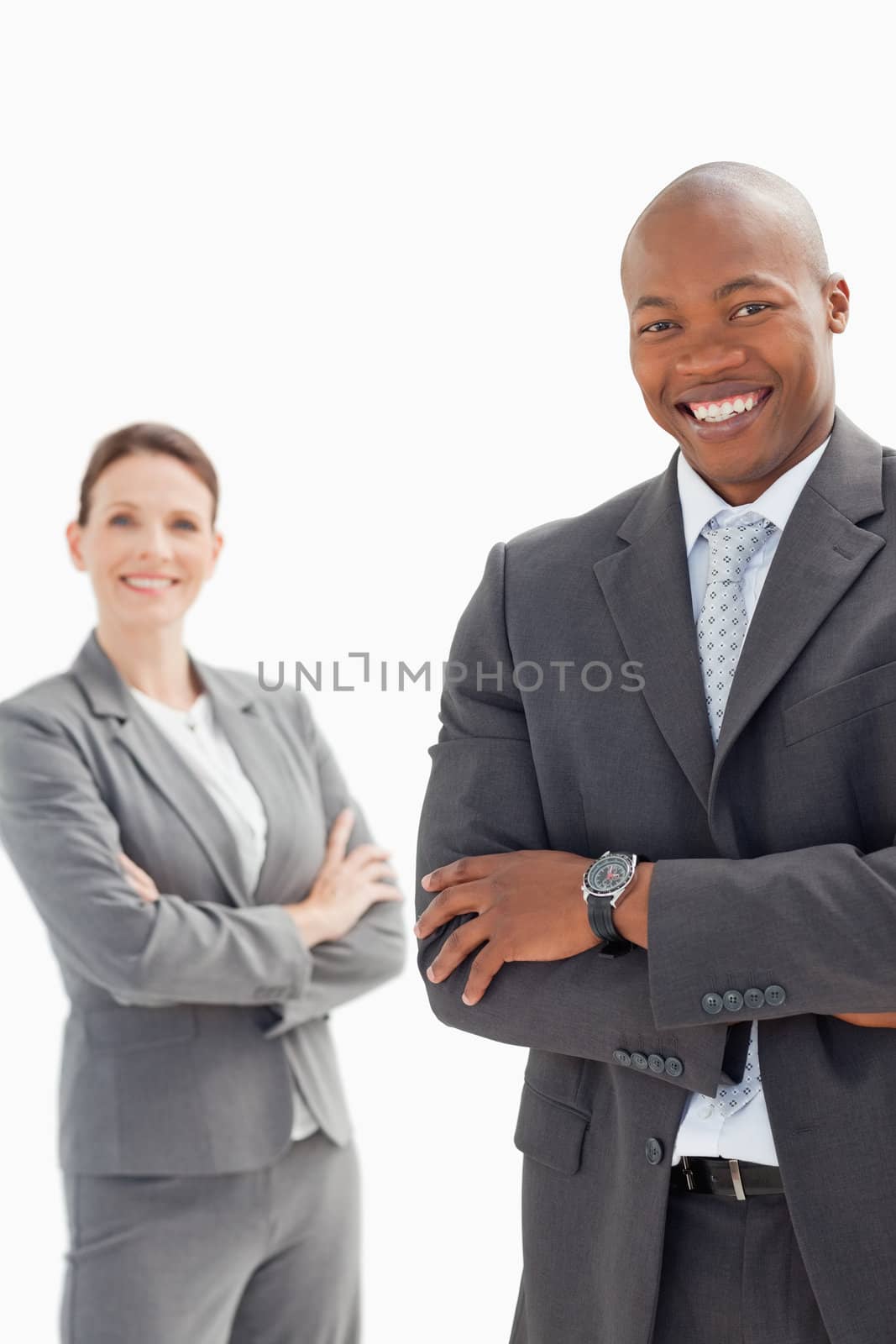 Smiling businessman and woman with folded hands by Wavebreakmedia