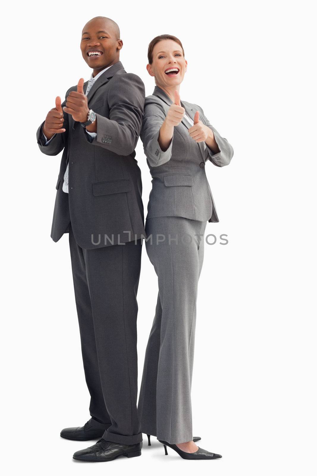 Smiling business people with their thumbs up