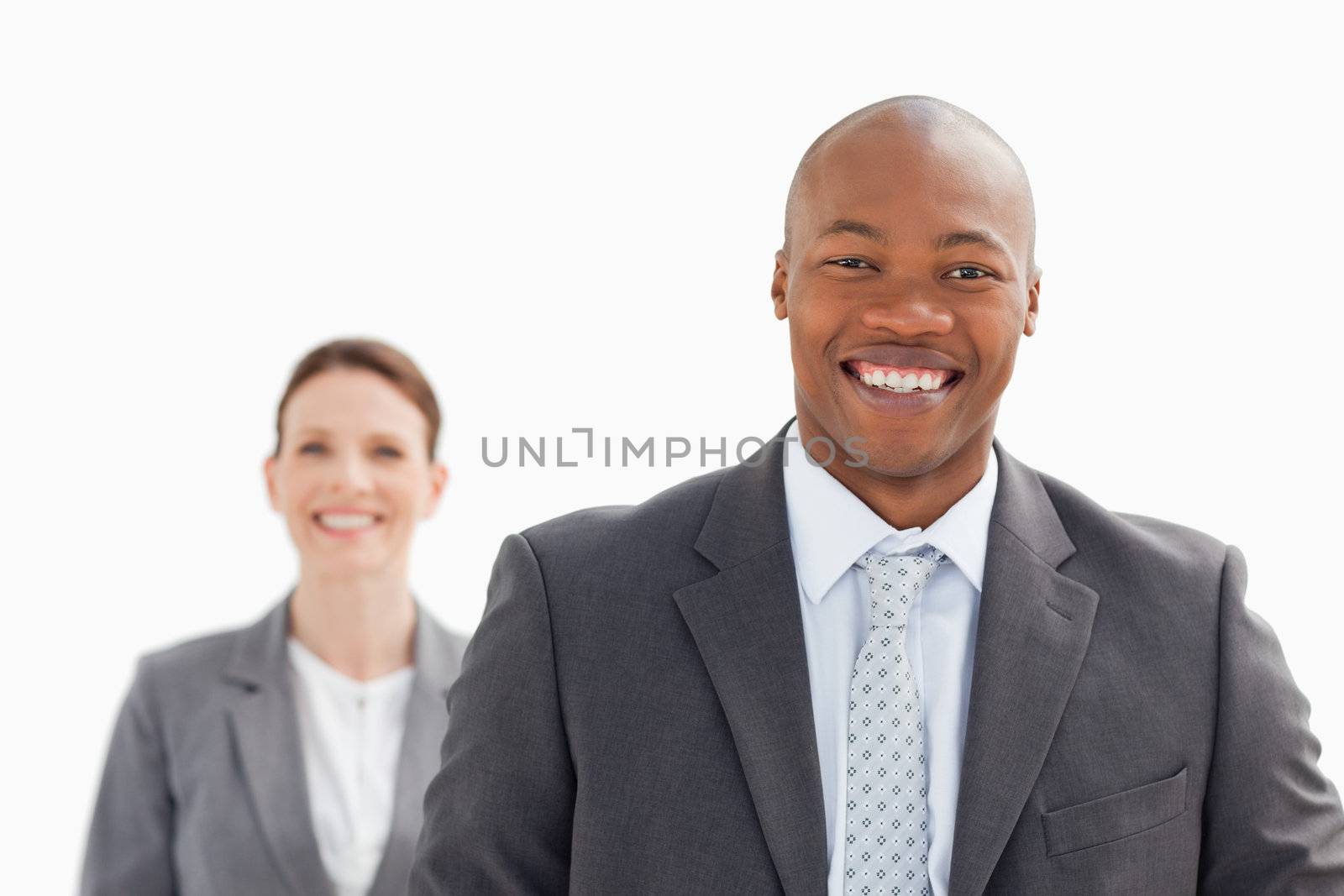 A smiling businesswoman stands behind smiling business man