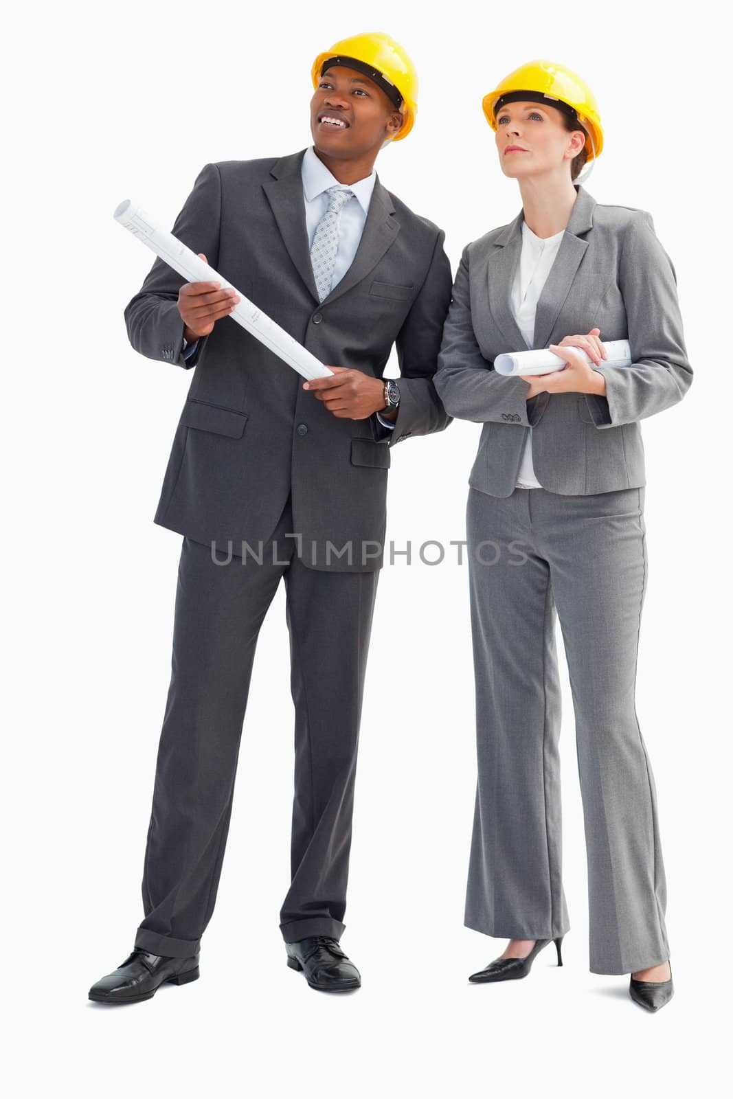 A businessman and woman with notes and hard hats on