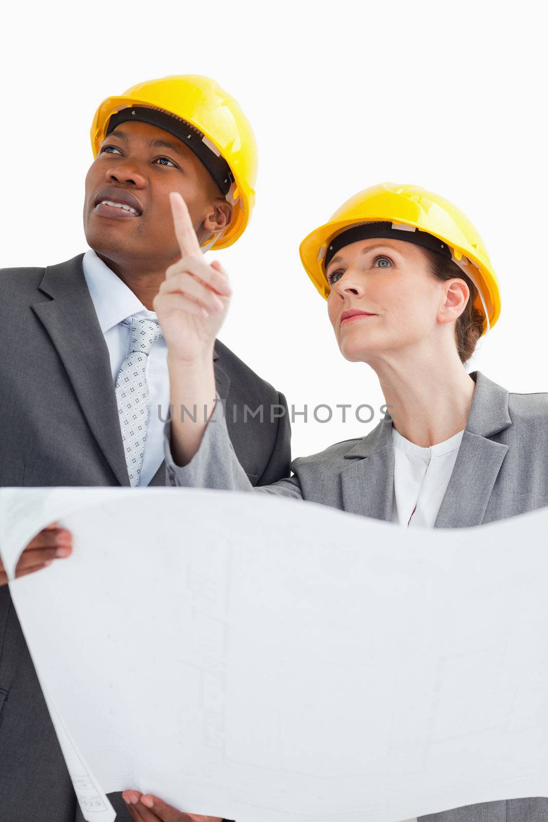 Business people wearing hard hats are talking by Wavebreakmedia