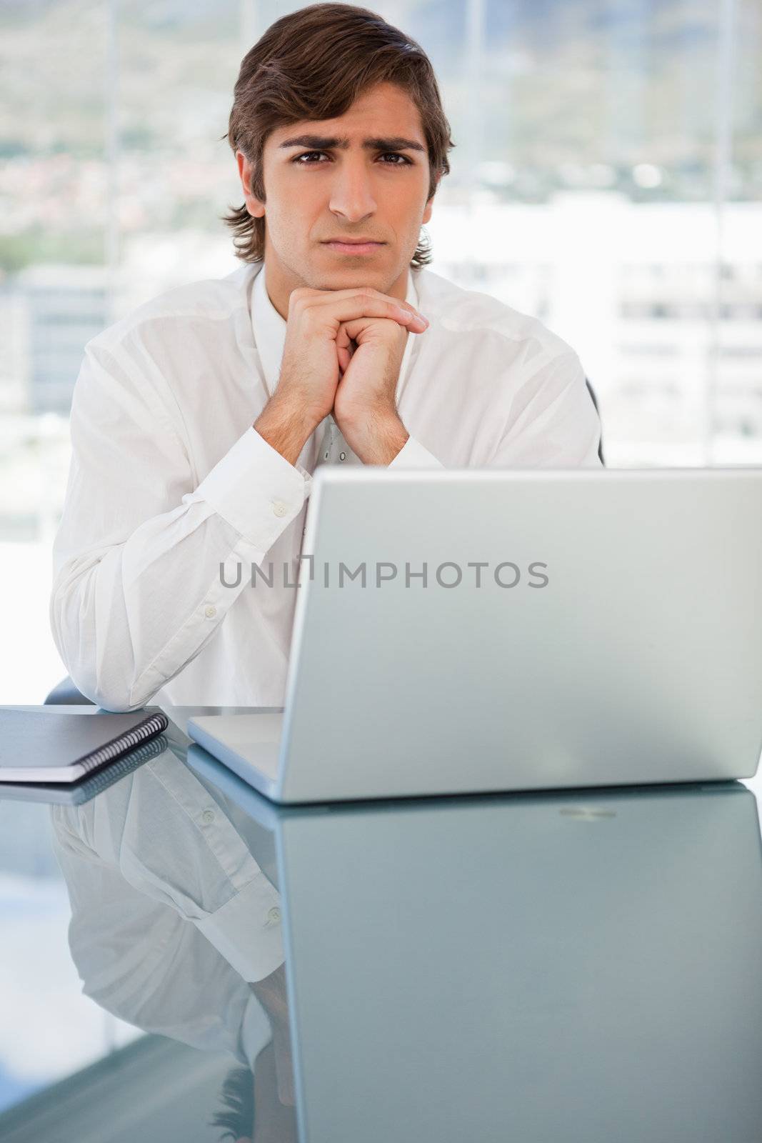 Serious young businessman with a laptop by Wavebreakmedia