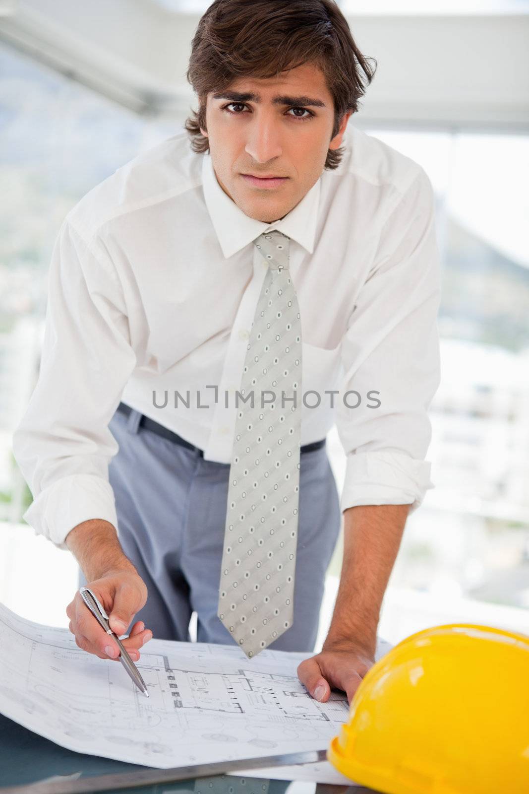 A businessman with a hard hat and construction drawings