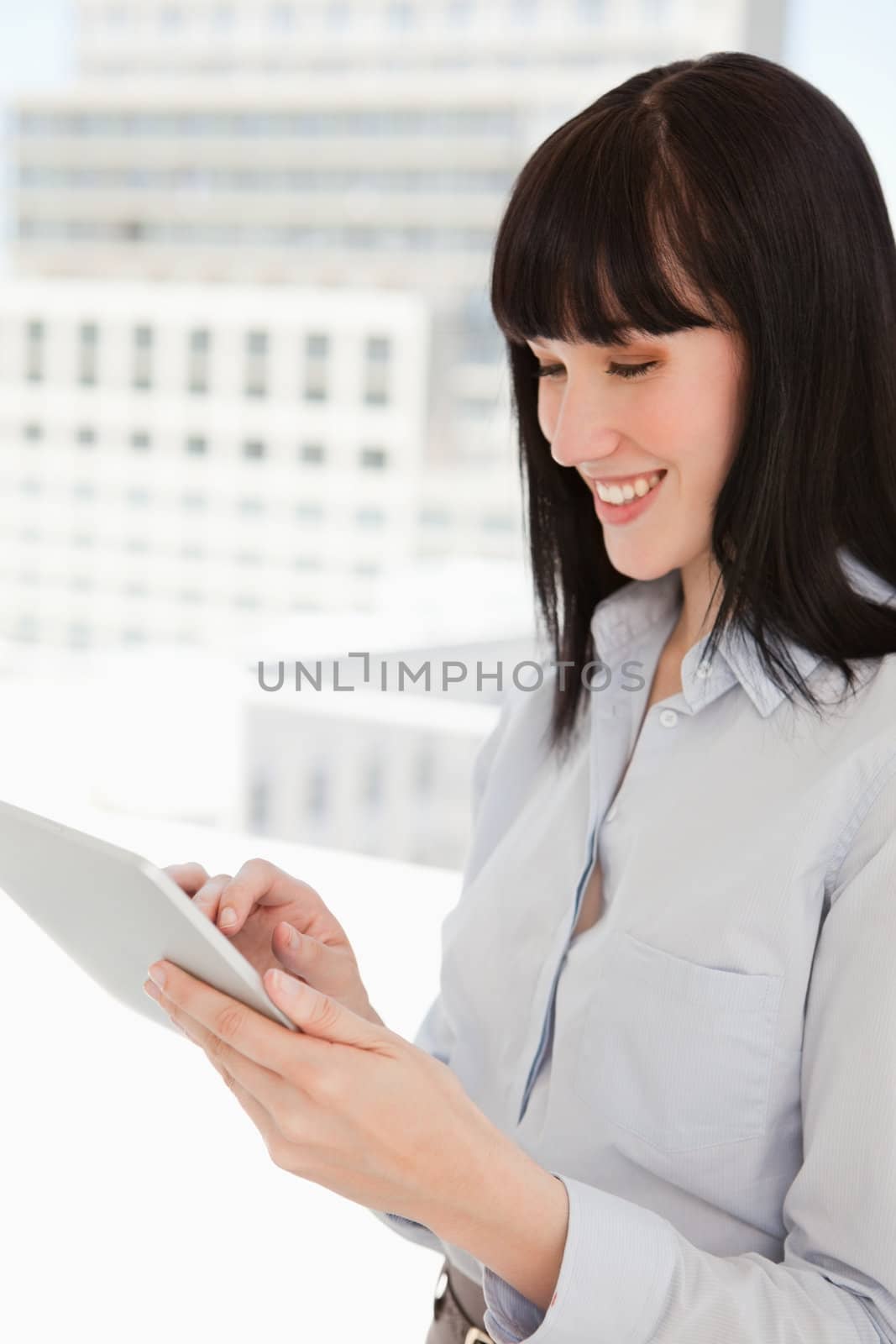 A smiling woman in her office using her tablet pc 