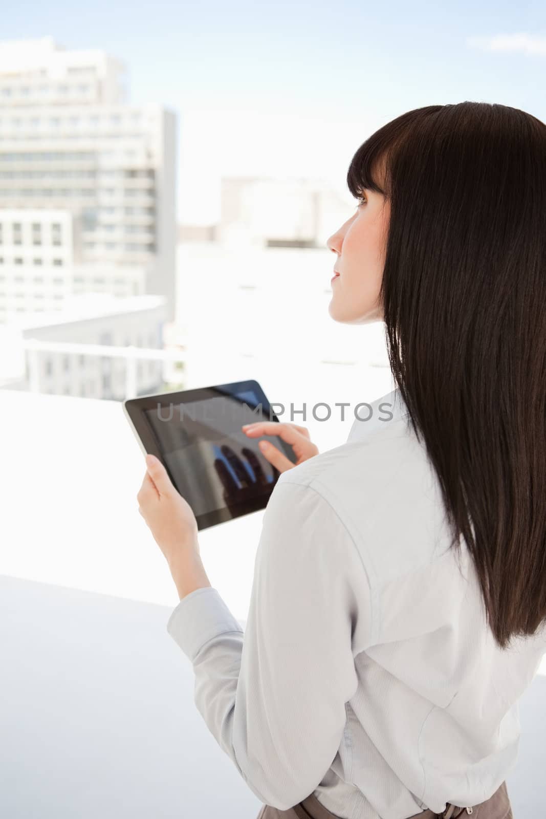 A business woman uses a tablet pc in her office as she looks up