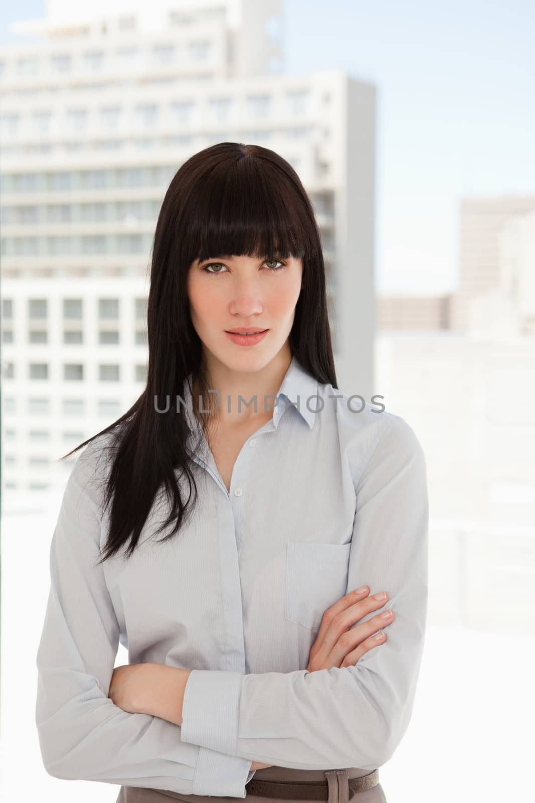 A business woman in her office with her arms crossed over