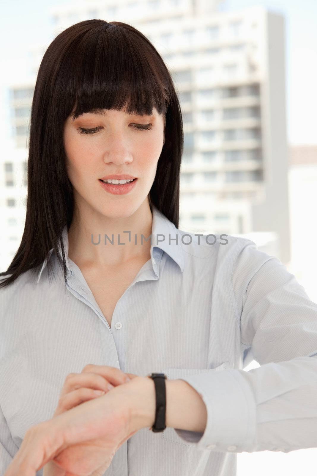 Close up of a woman checking the time on her watch by Wavebreakmedia
