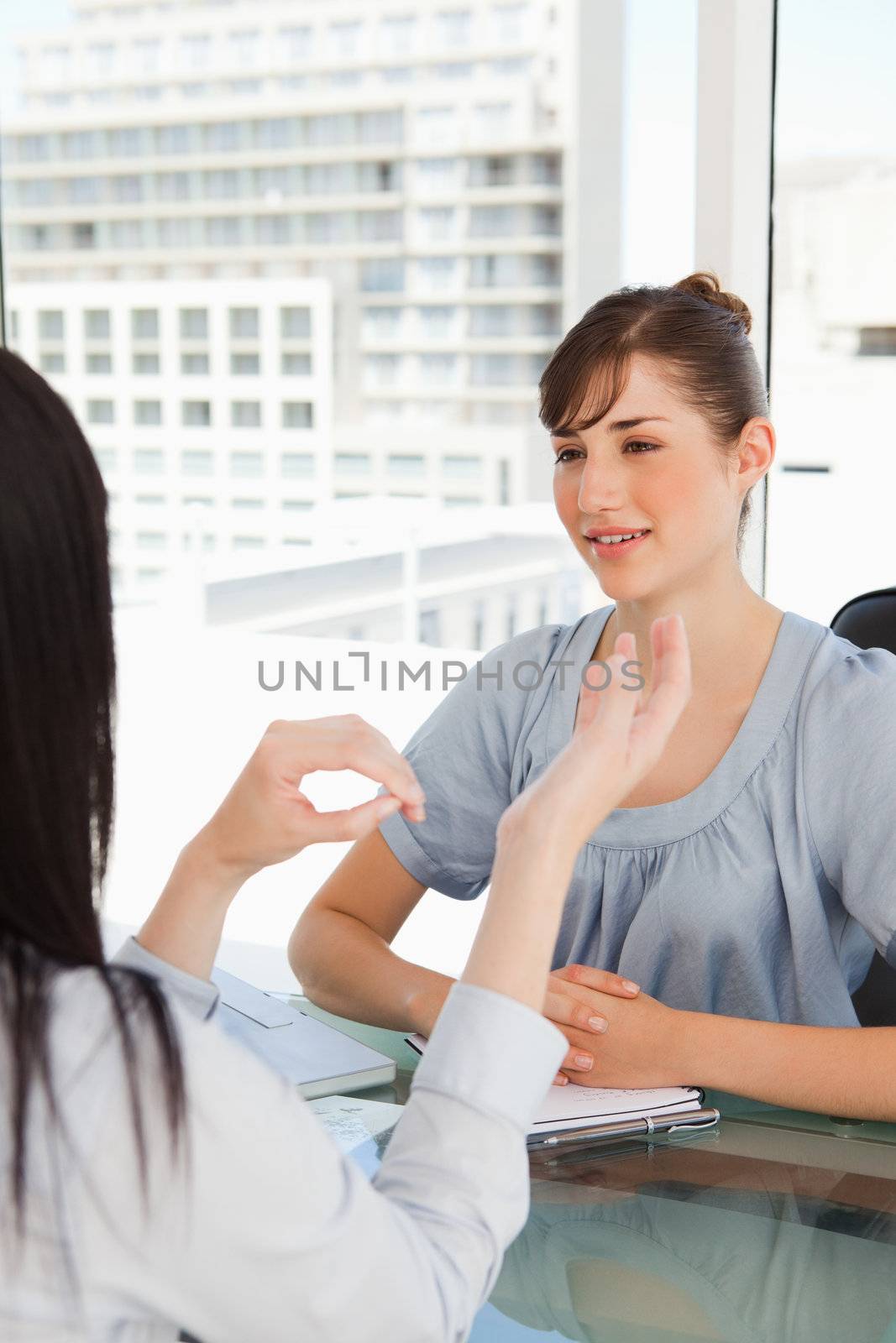One business woman chats to another while in her office