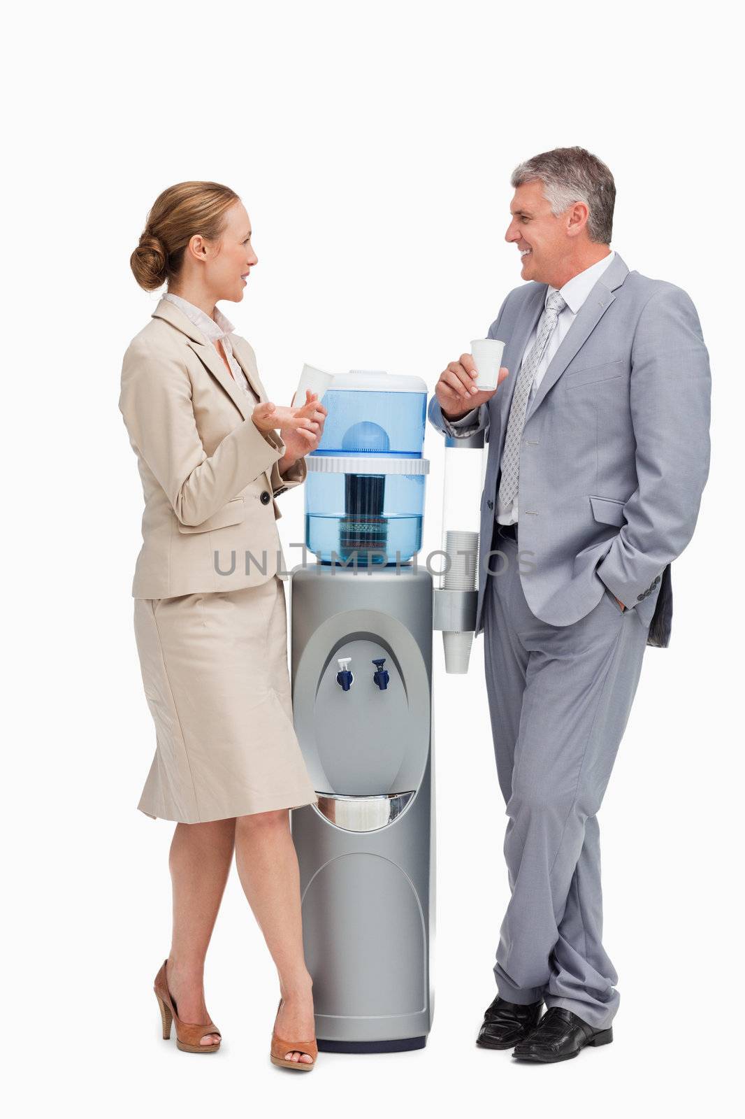 Business people talking next to the water dispenser  against white background