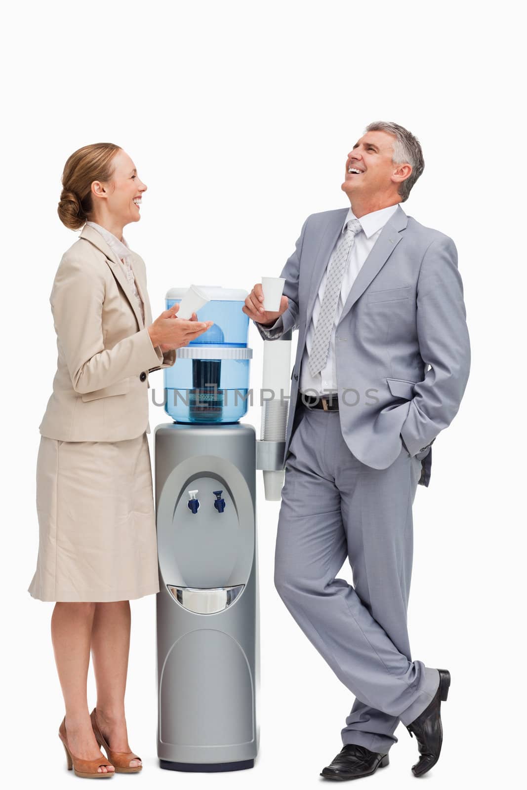 People in suit laughing next to the water dispenser against white background