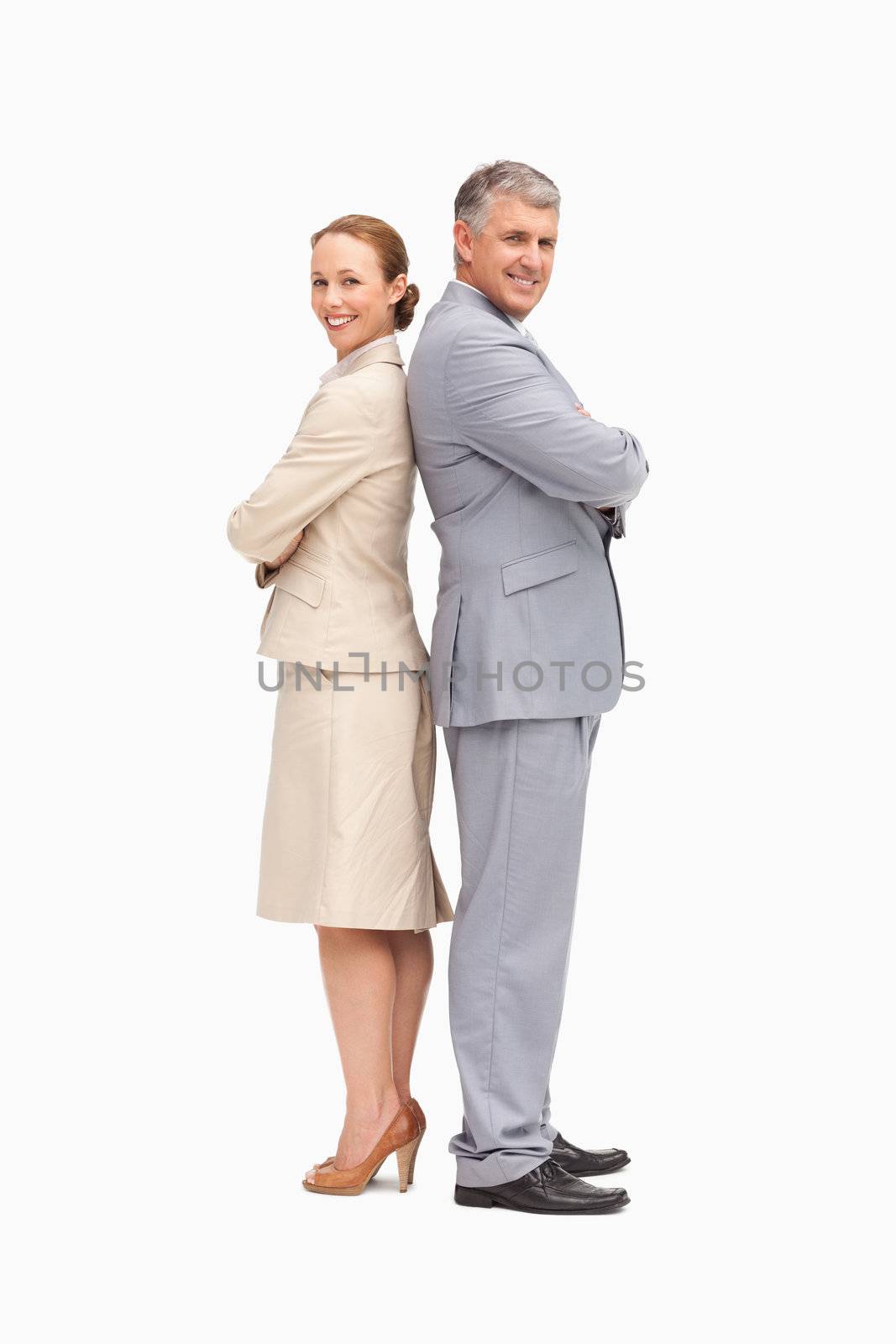 Portrait of smiling business people back to back against white background