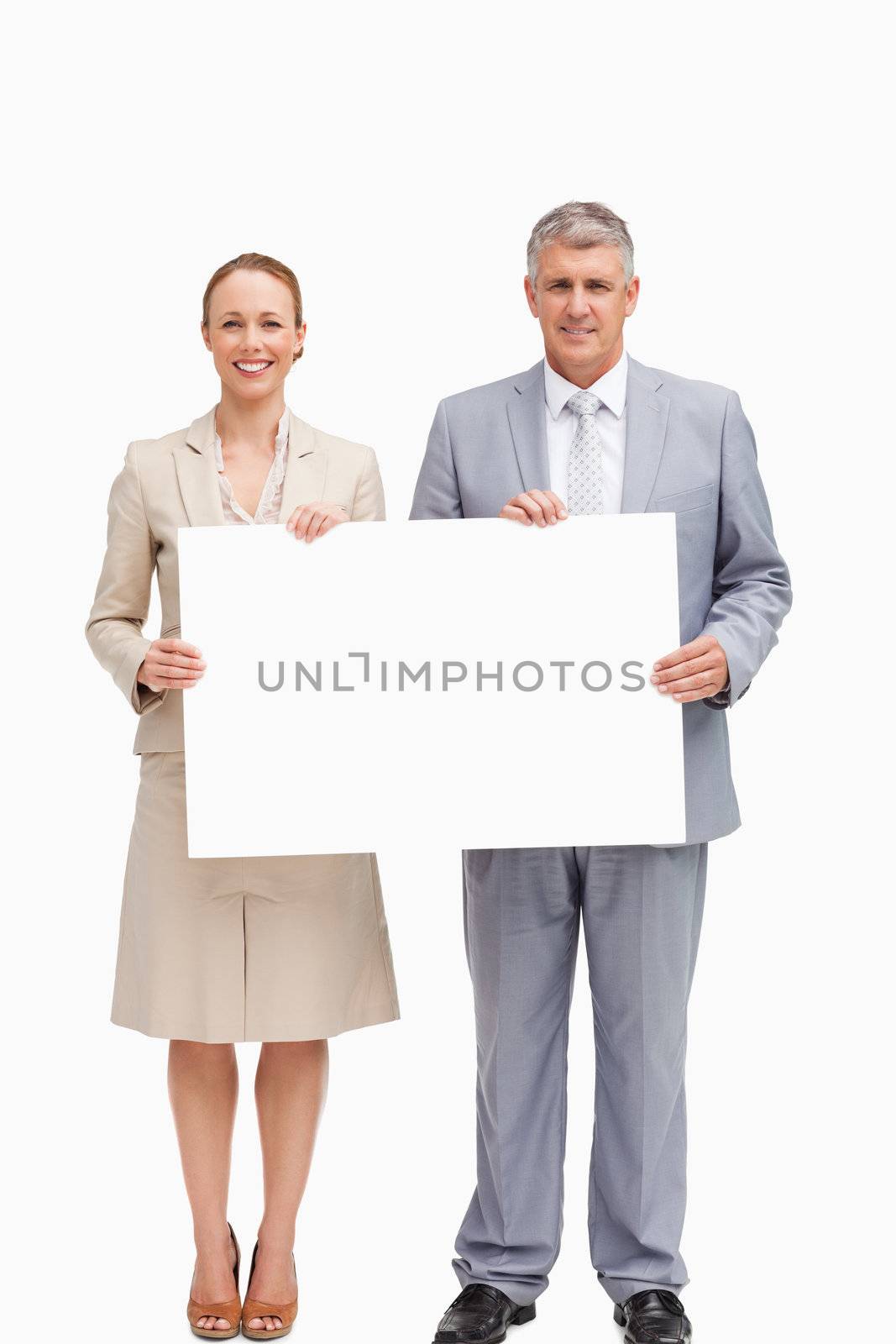 Business people smiling while holding a poster against white background