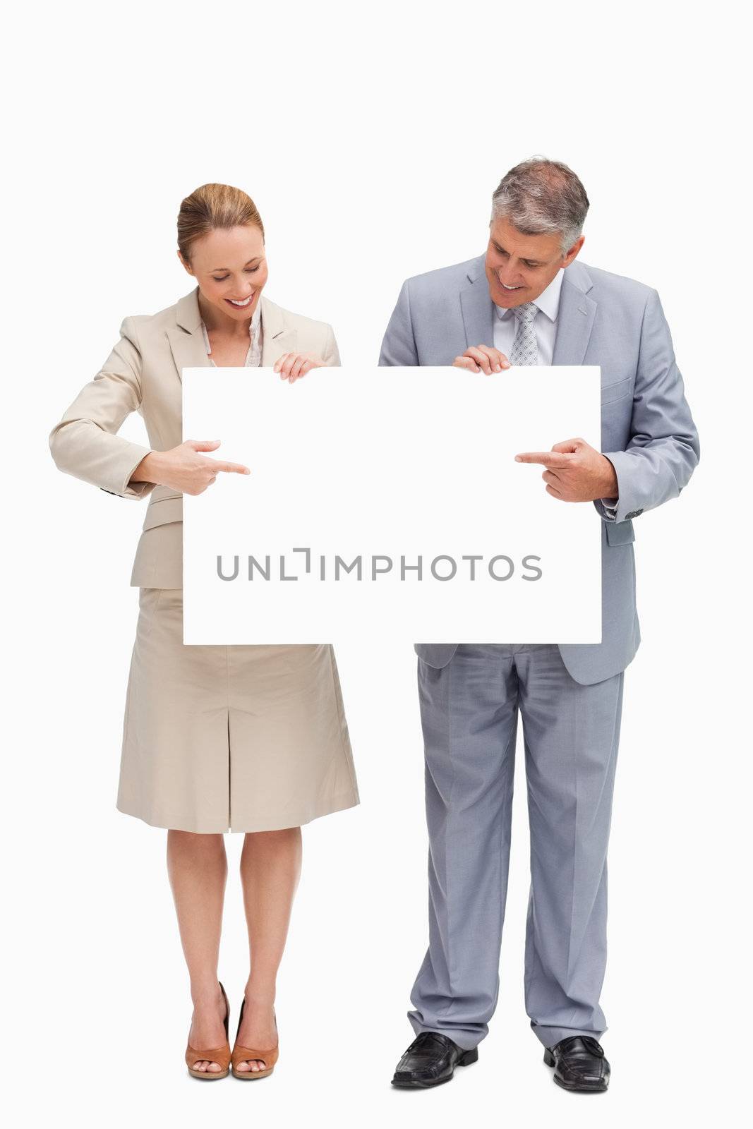 Smiling business people holding a poster against white background