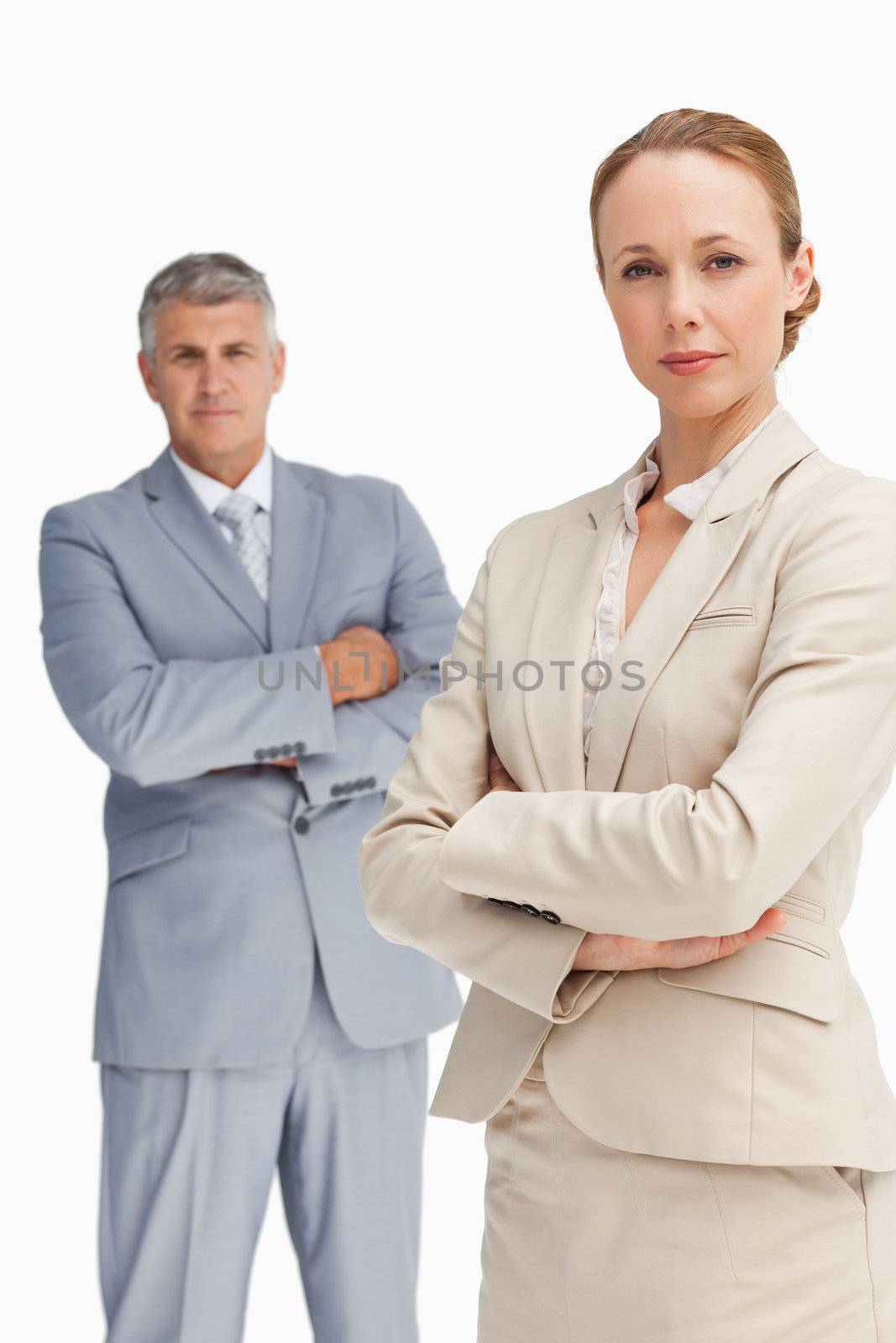 Close-up of a serious business people with folded arms against white background