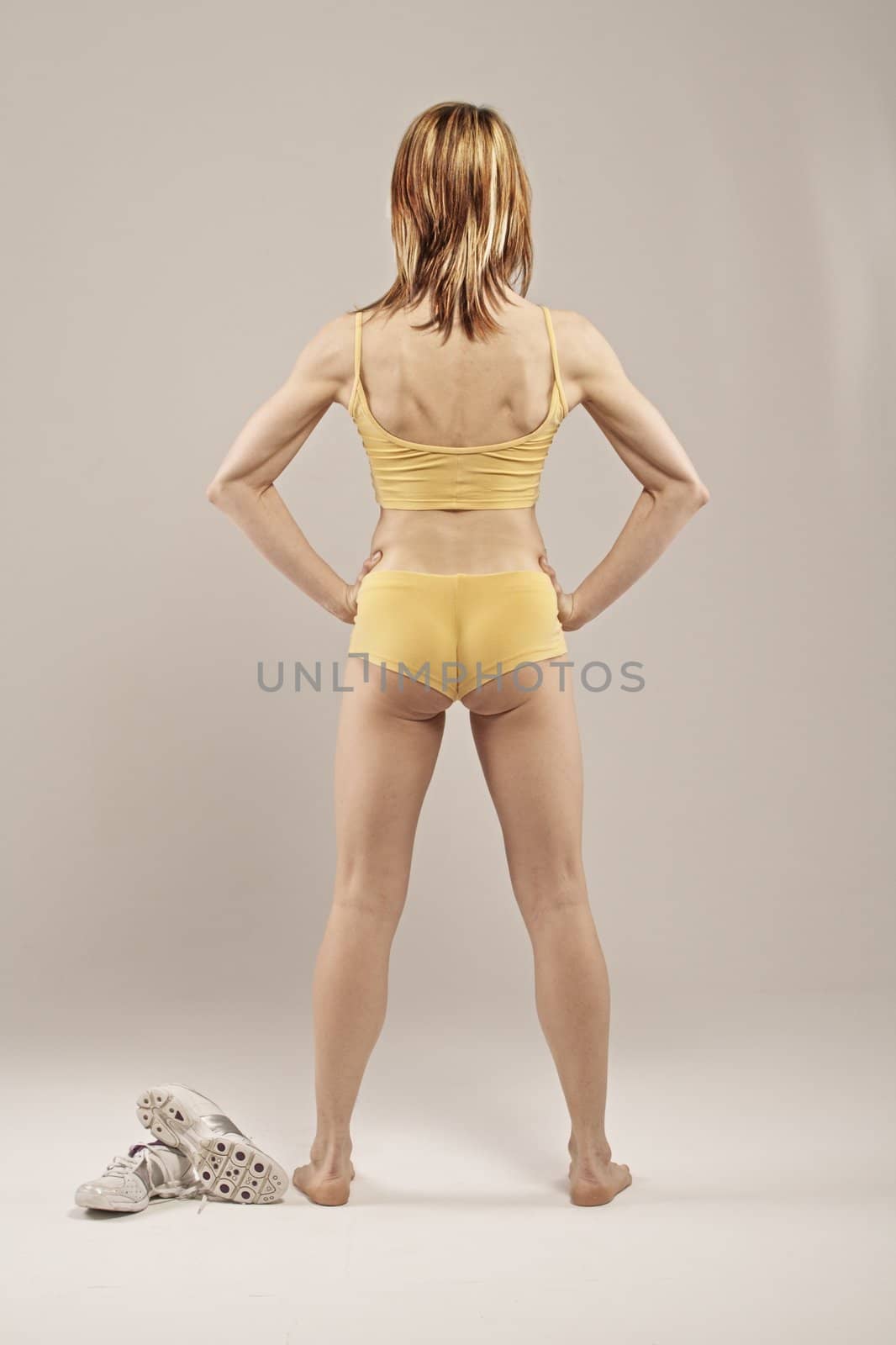 Back view of a muscular woman and sneakers by icephotos