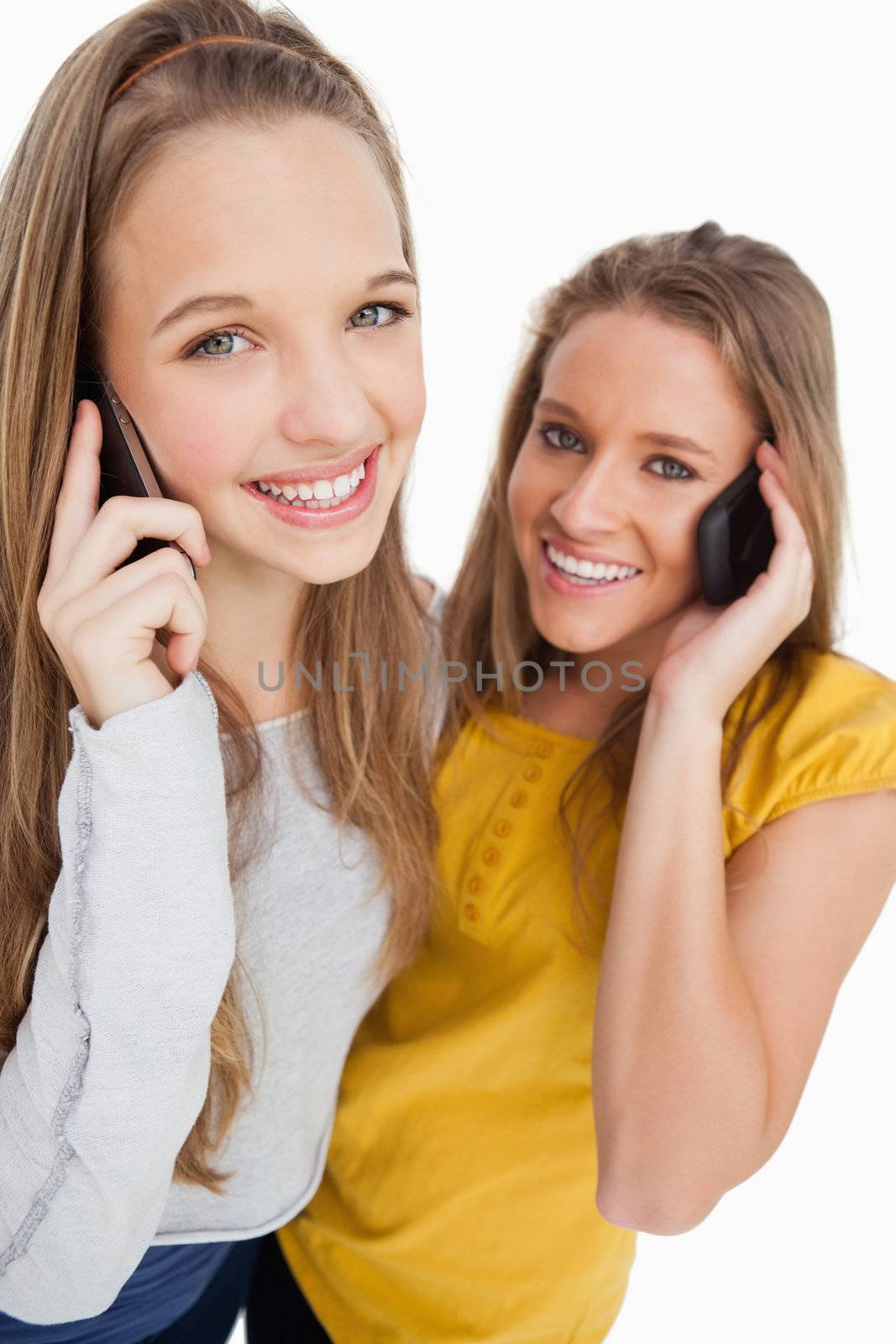 Close-up of two students smiling on the phone by Wavebreakmedia