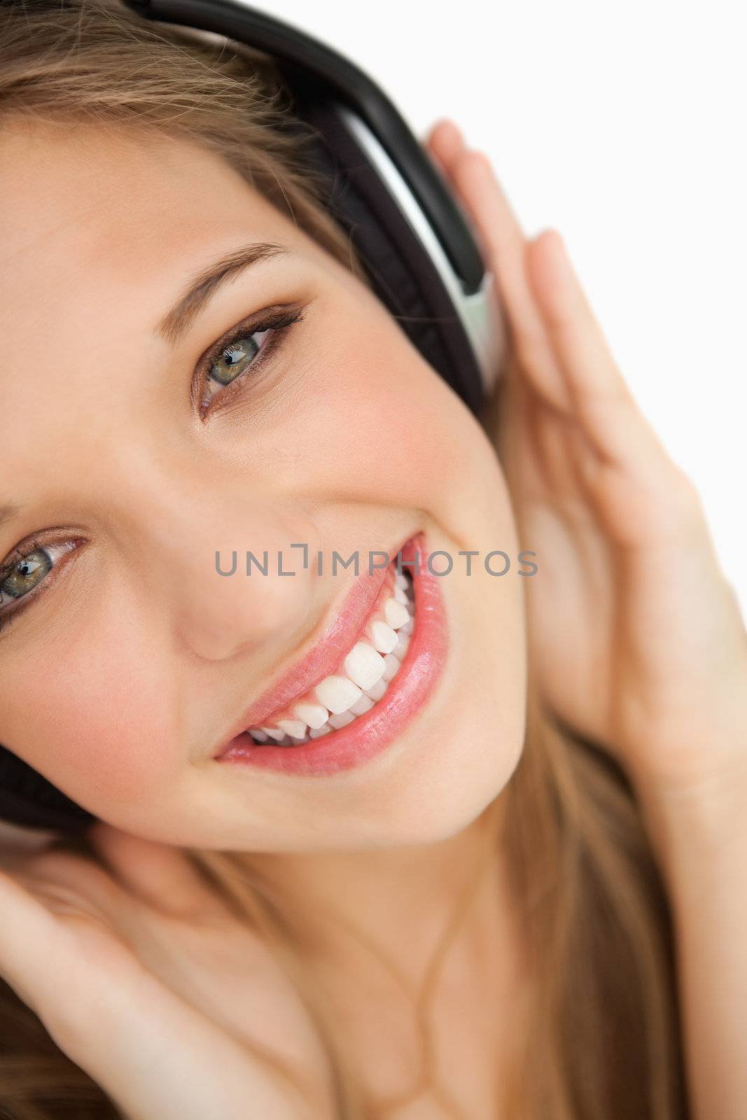 Close-up of a beauty listening to music against white background