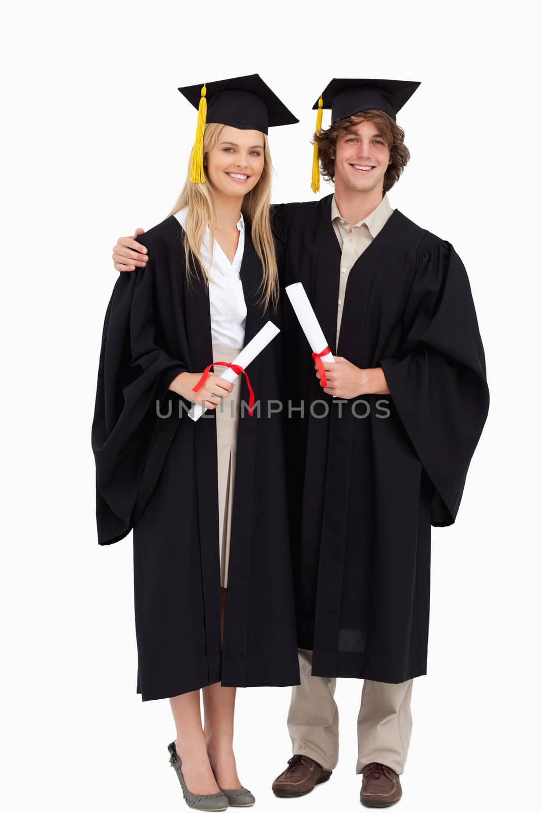 Two students in graduate robe shoulder to shoulder by Wavebreakmedia