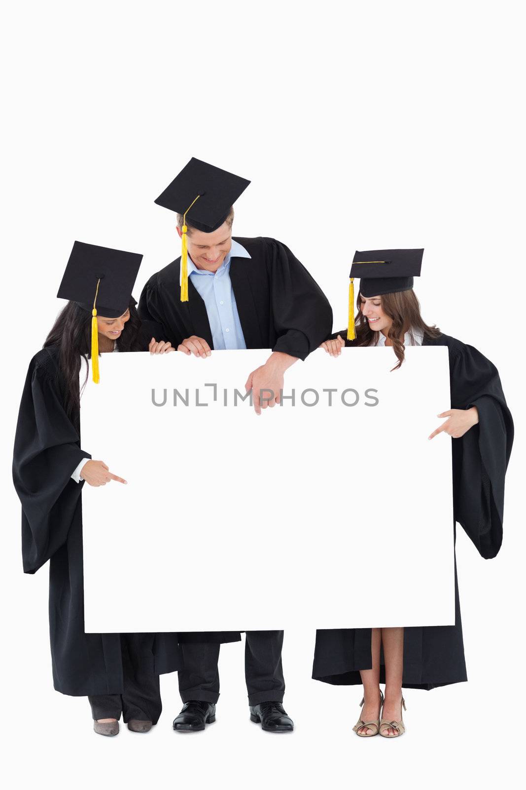 Three graduates point to a spot on the balank sign which will be filled by infromation