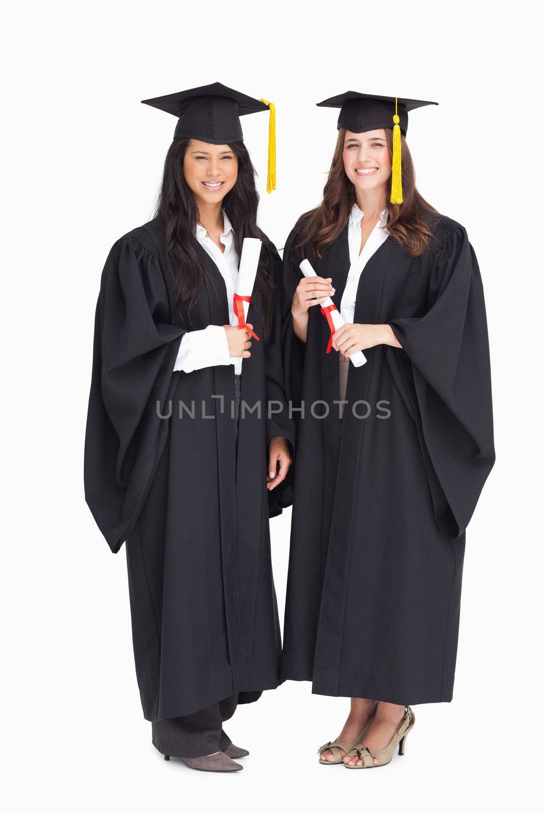 A full length shot of two graduating female students 