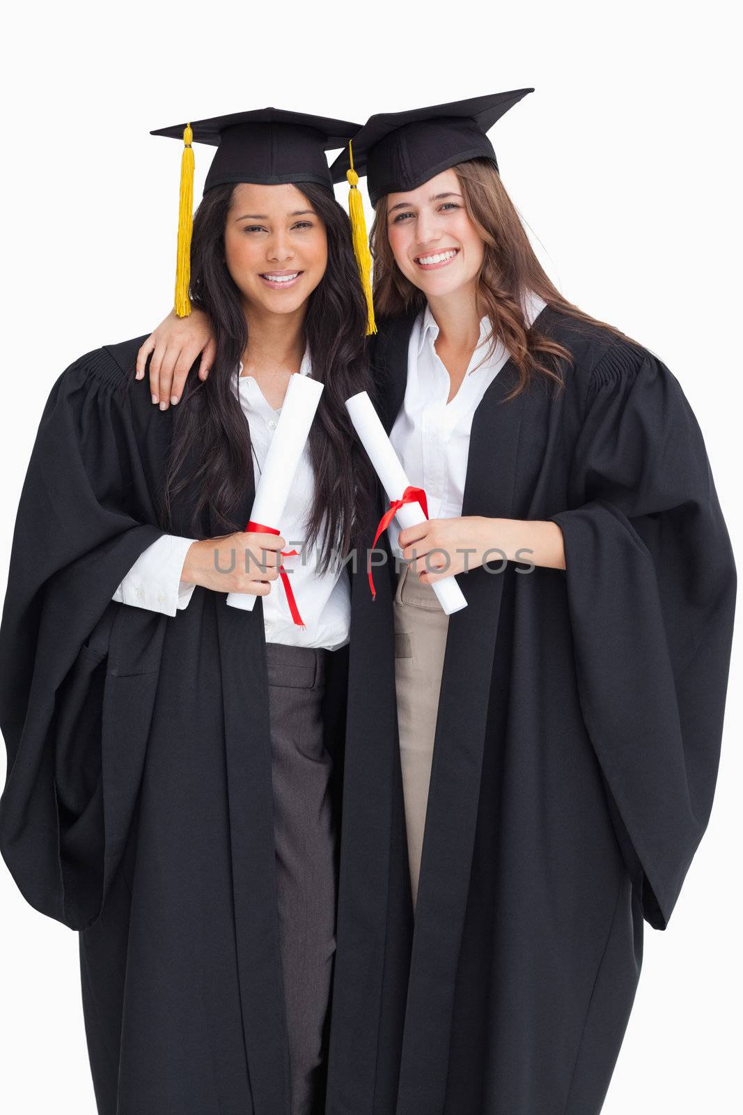 Two women embracing each other after they graduated from univers by Wavebreakmedia