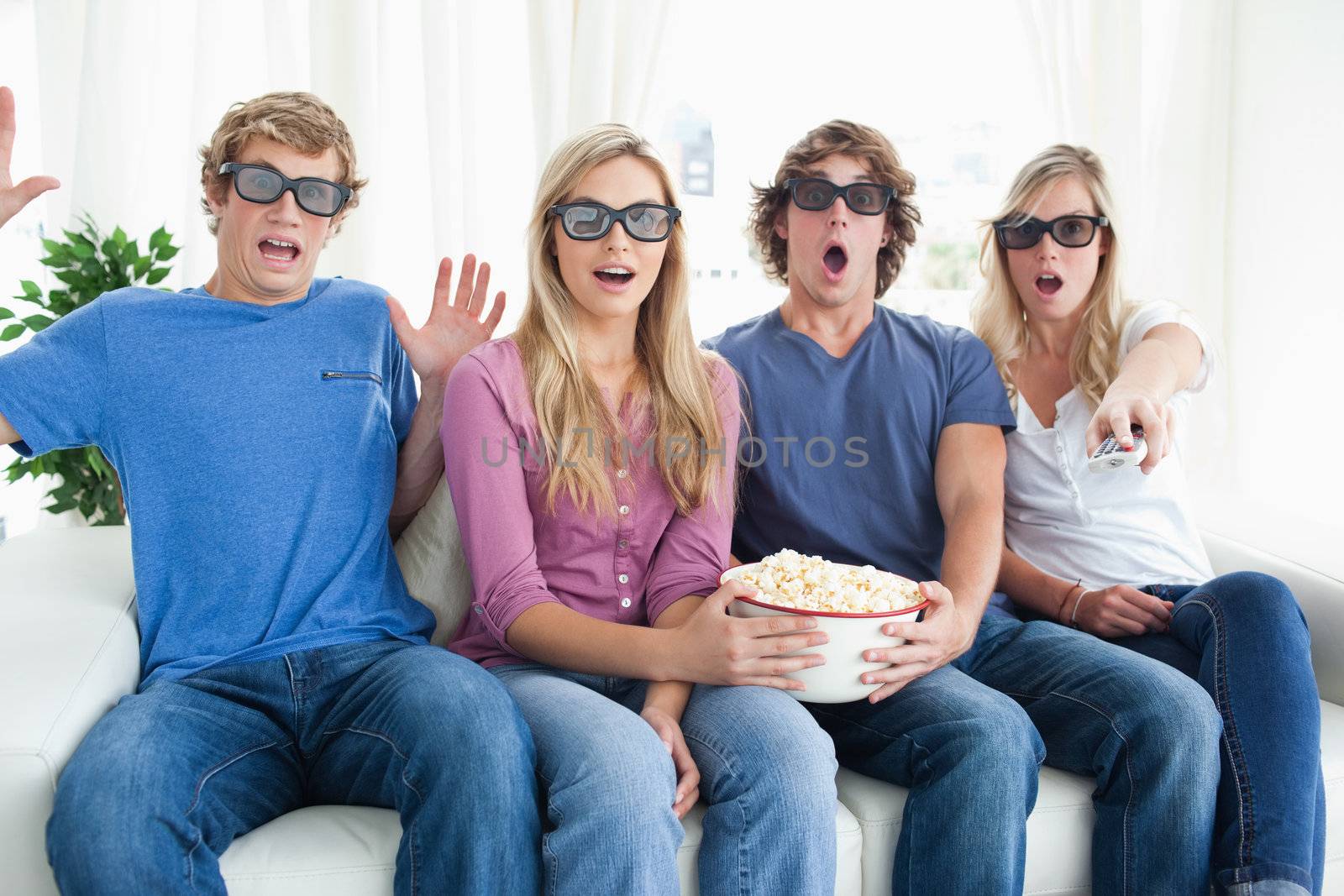 Friends shocked as they watch a scary 3d movie by Wavebreakmedia